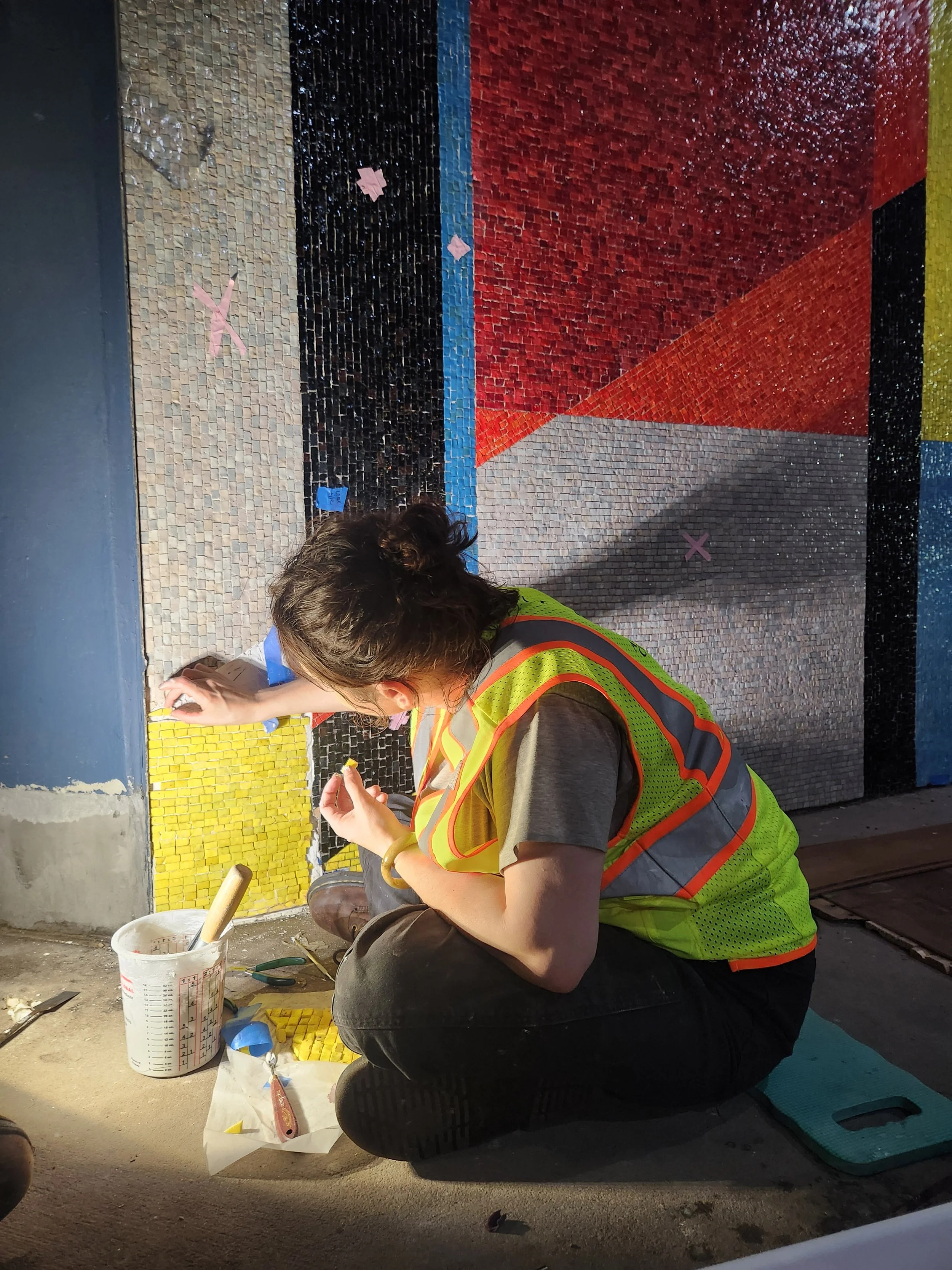 A conservator hand-sets mosaic tesserae.