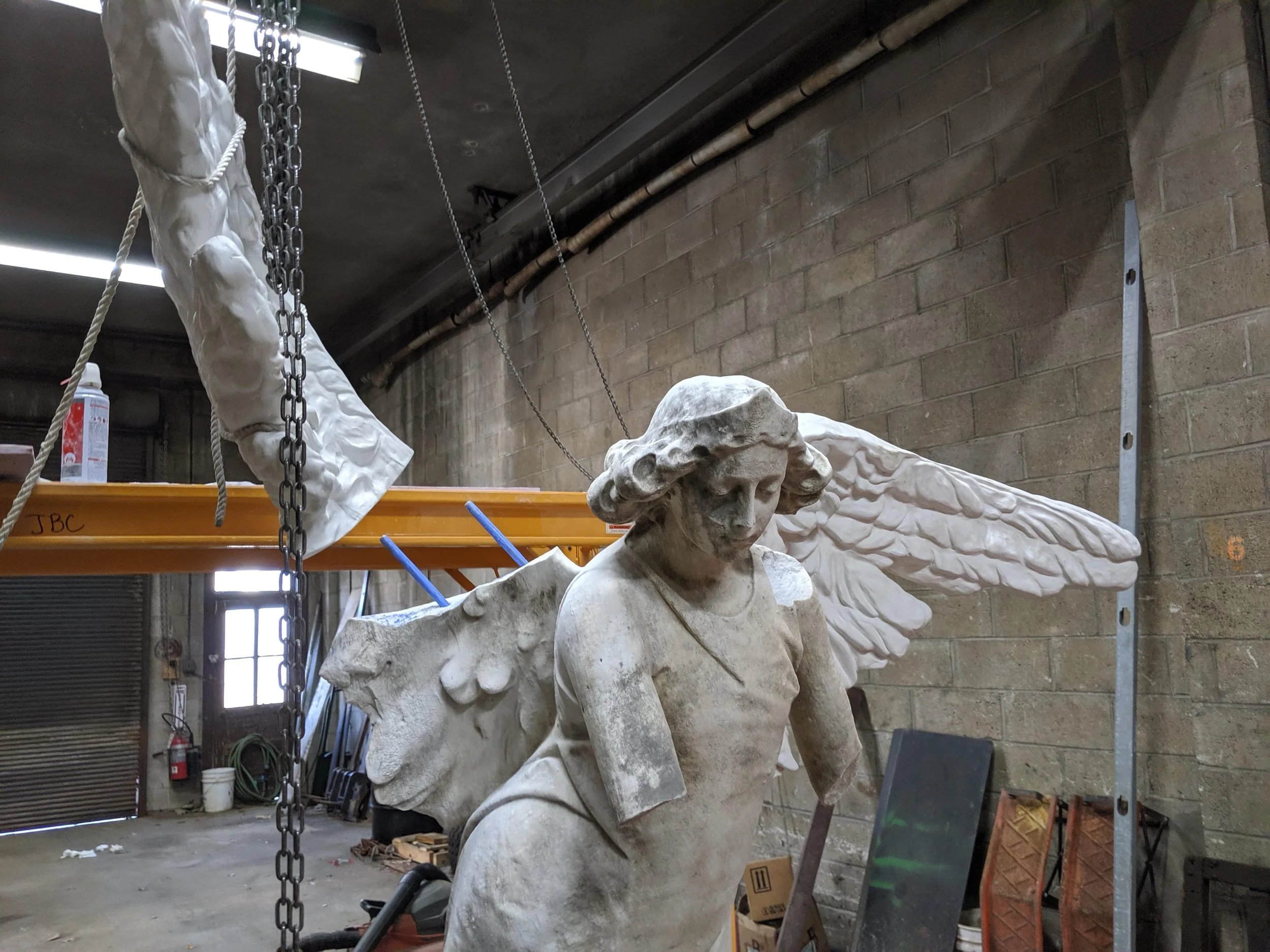 Attaching a composite replica wing to a damaged marble sculpture.