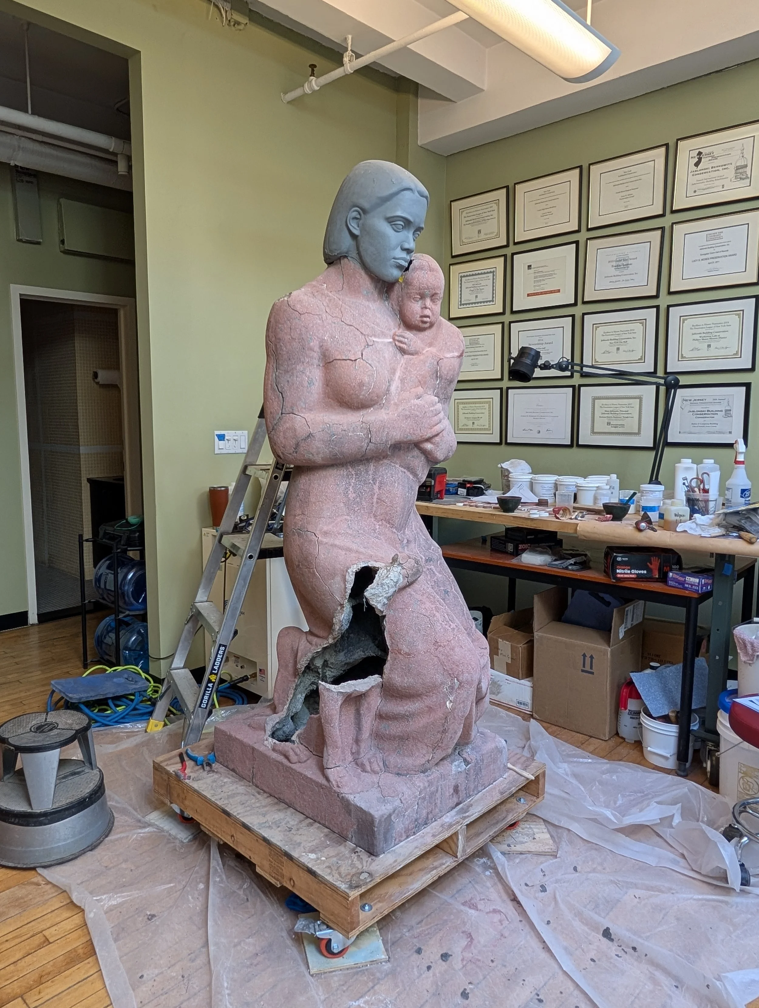 Test fitting a clay model of a replica head before casting.