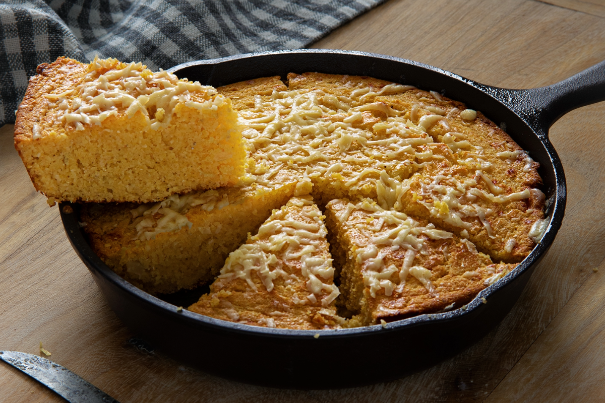 Photo of cornbread sliced in a cast iron skillet