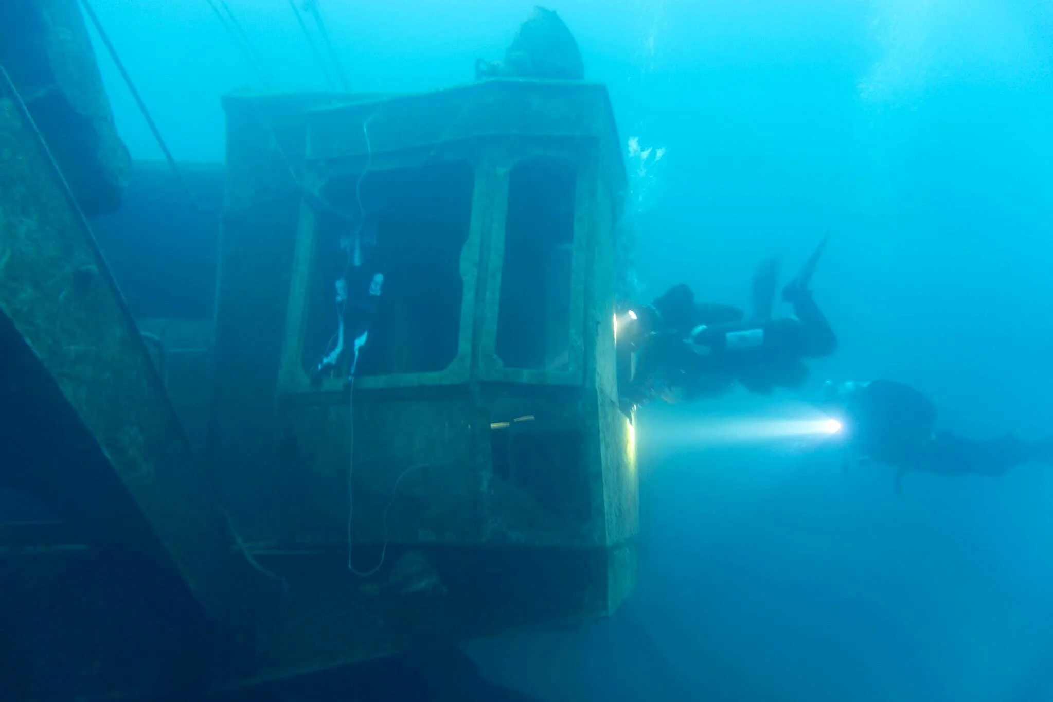 Scuba diving large abandoned crane in ocean