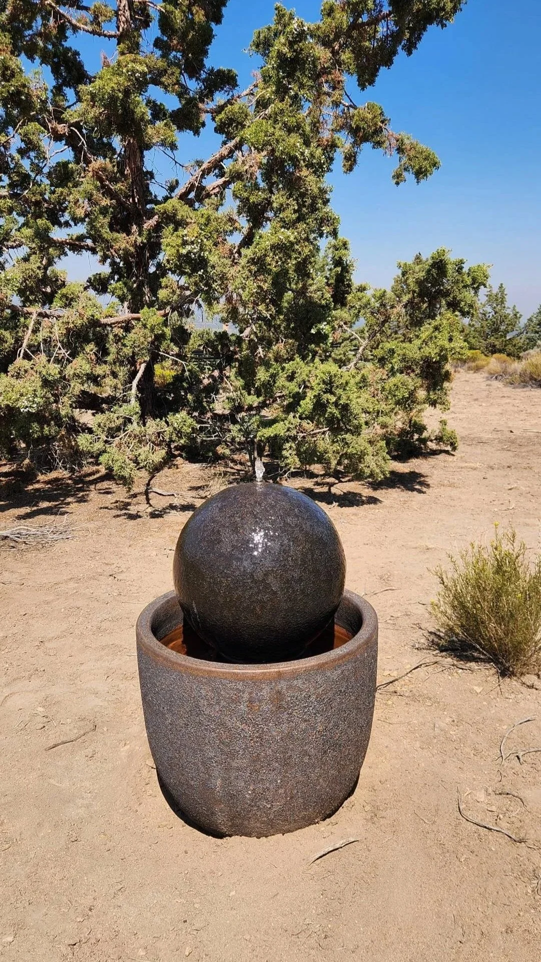  Third Prize &middot; 2026  Beth Brown  Beth Brown created a fountain using three of our basalt-glazed pieces, two planters and a garden sphere. Her photo captures how water flows evenly over the sphere, shimmering as it catches the rough textures of