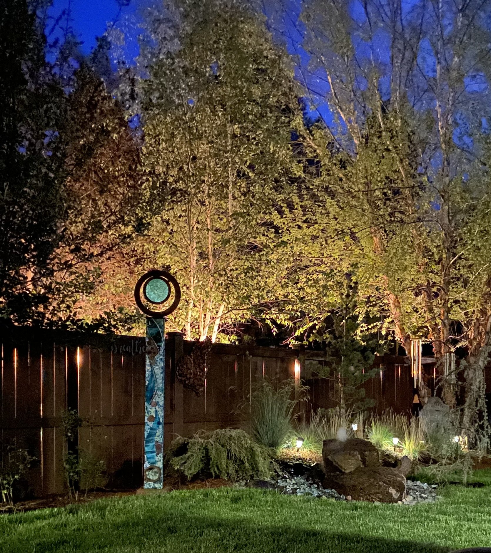  First Prize &middot; 2024  Trish Pitzerak  Fell in love with this turquoise glass and steel totem made by Z Glass Ac and had to have it for this corner of her yard. The back lighting, the orientation looking up from a lower angle and the colors real