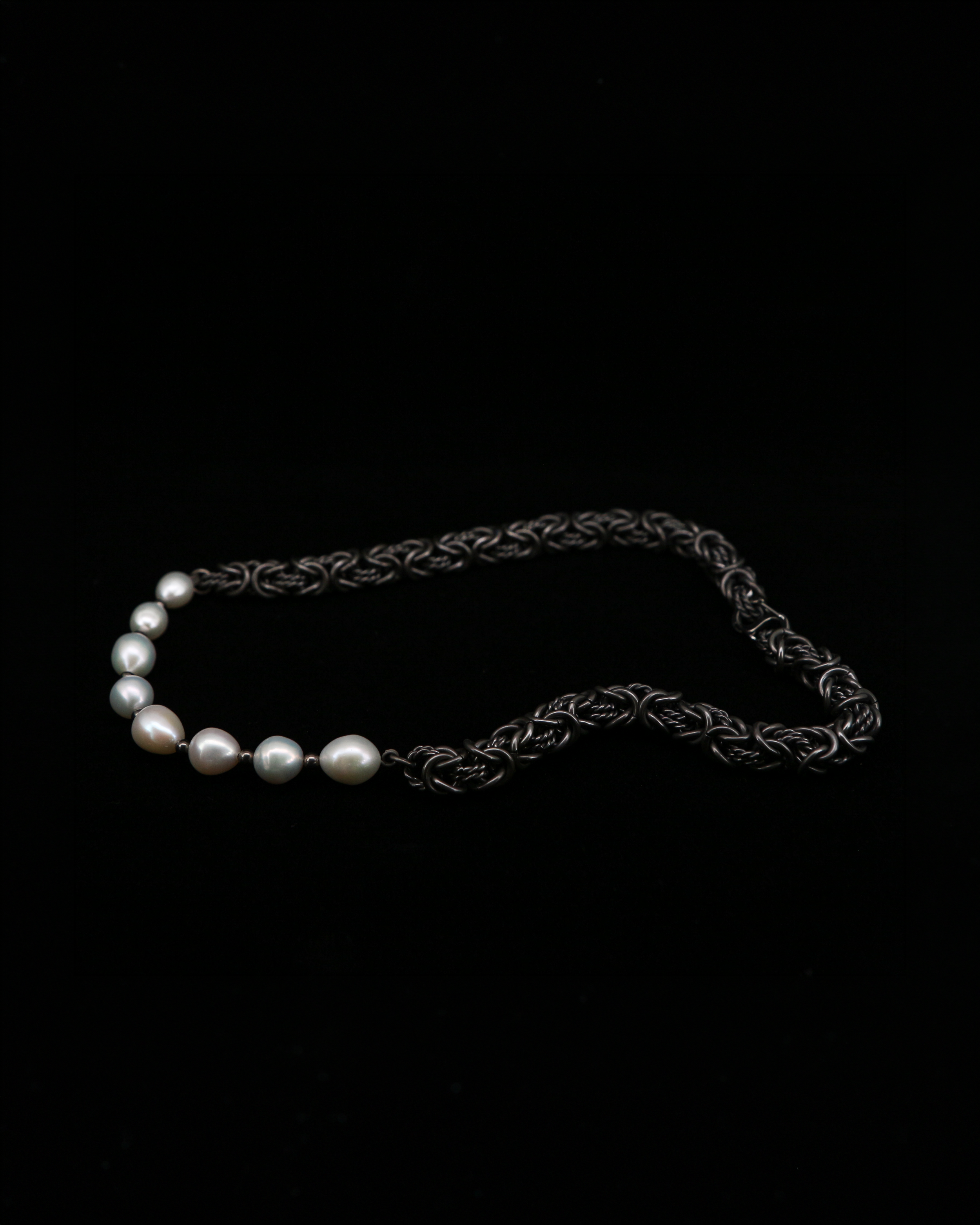 Side view of the Dew Necklace, titanium Byzantine chain stretched out showing the weave