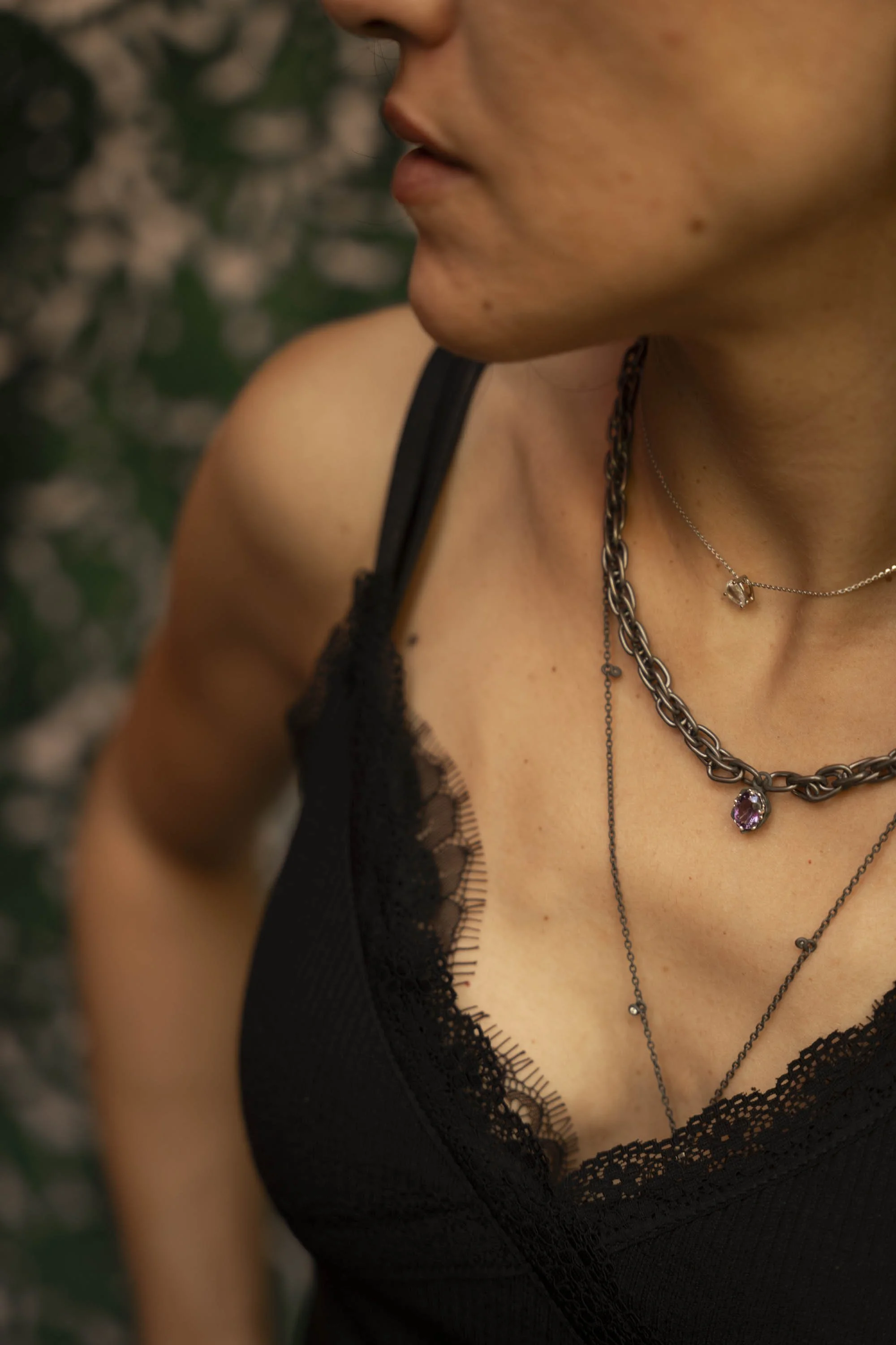 Woman wearing the Twine Necklace, amethyst pendant on titanium chain