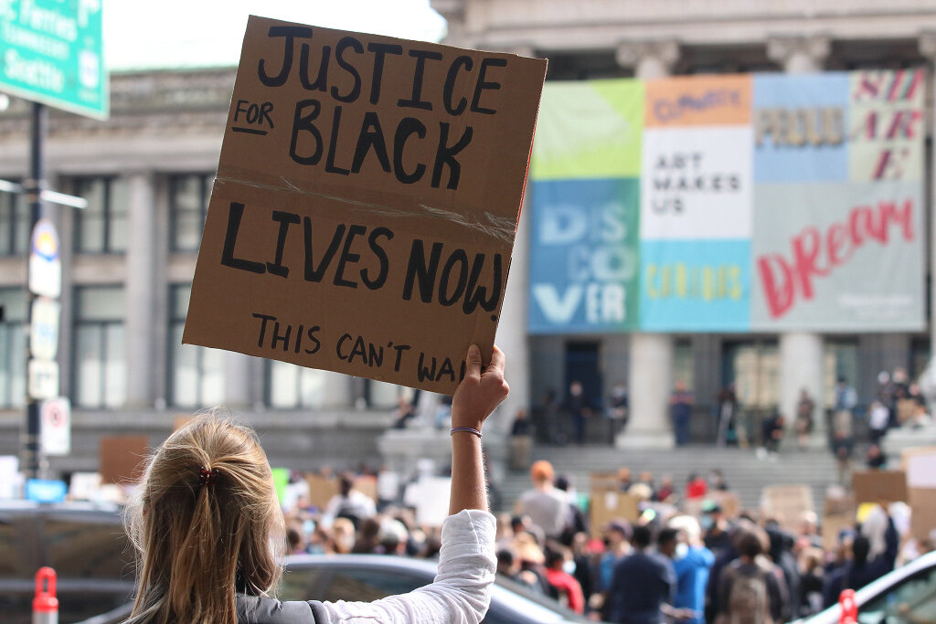 Woman with Justice for Black Lives Now sign