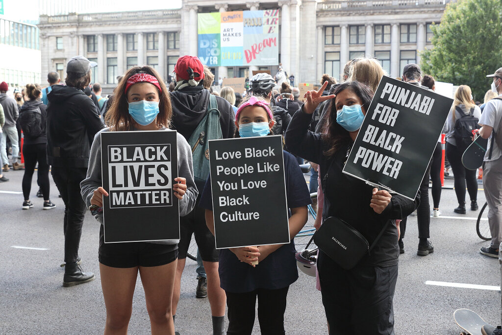 Women with signs supporting the black community