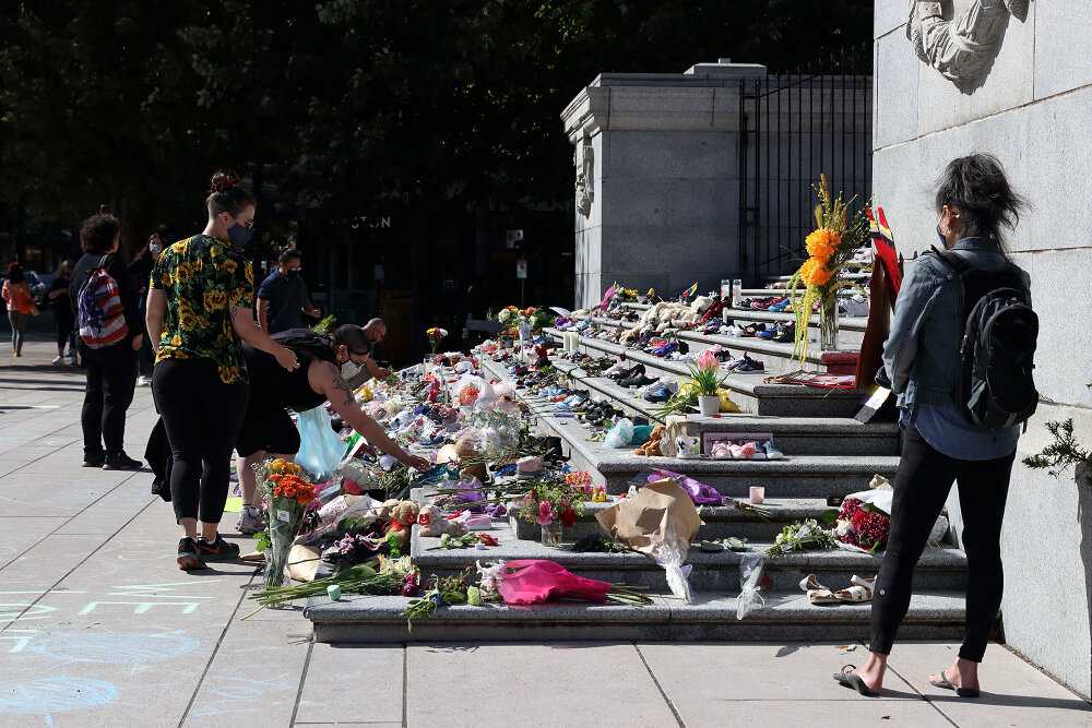 People lighting candles and offering tributes