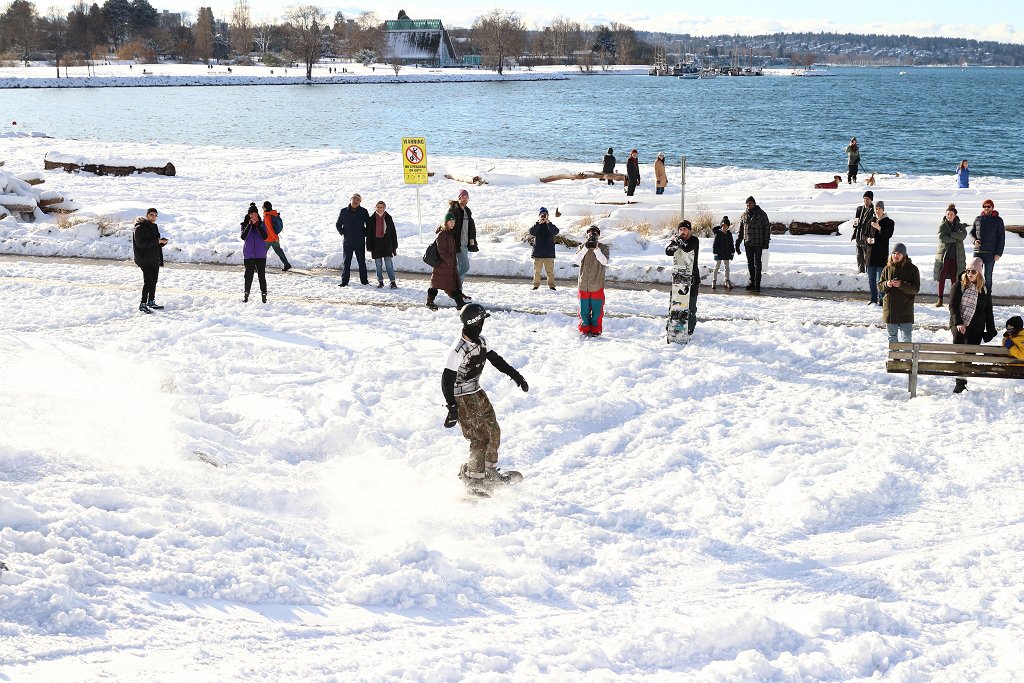 Onlookers gather to watch snowboarders