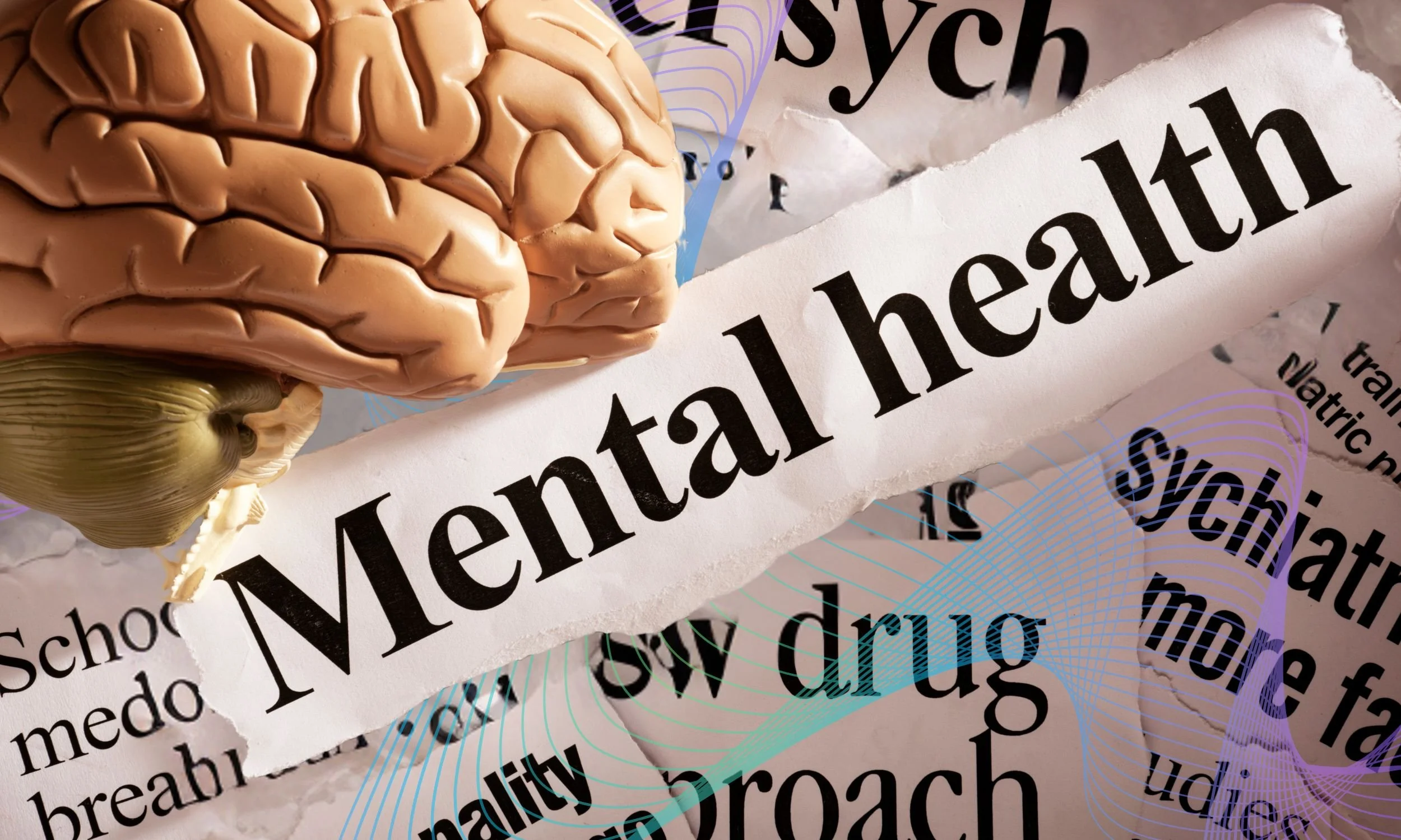 A model of a brain rests on torn newspaper clippings with headlines about mental health, new drugs, and psychiatric studies.