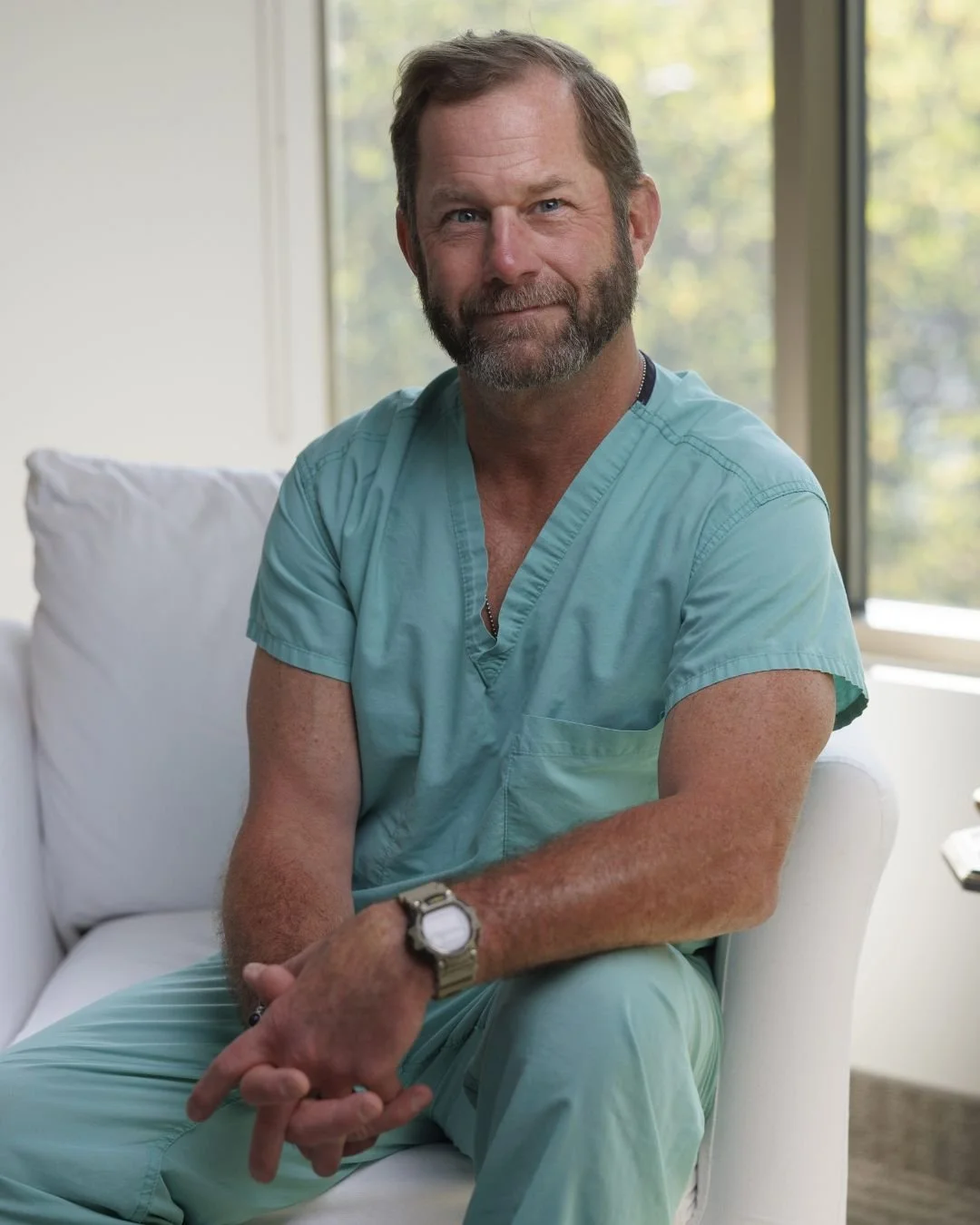 a person in scrubs sitting on a white chair