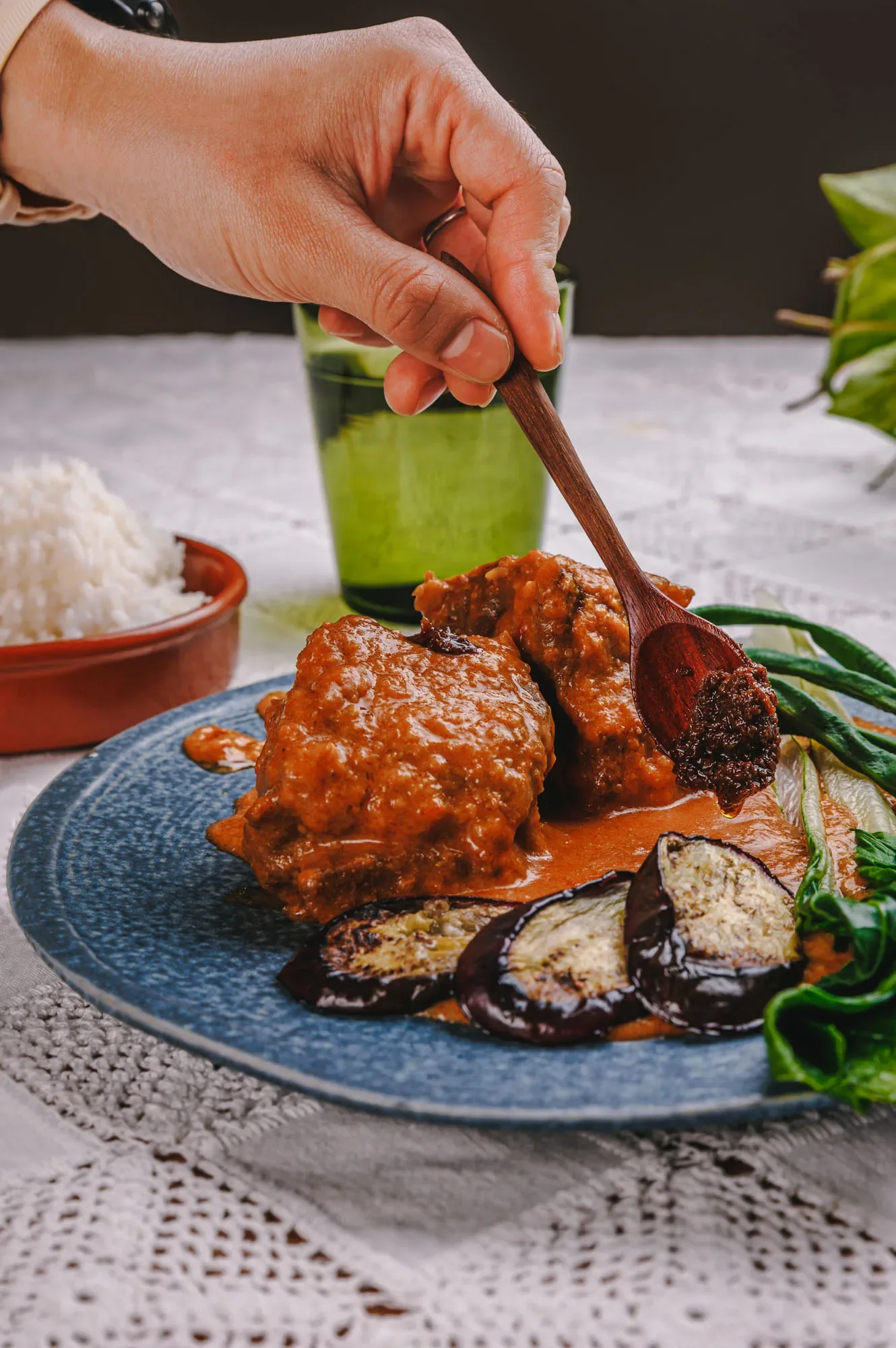 Preparation of a traditional dish from the Philippines with red sauce and eggplants