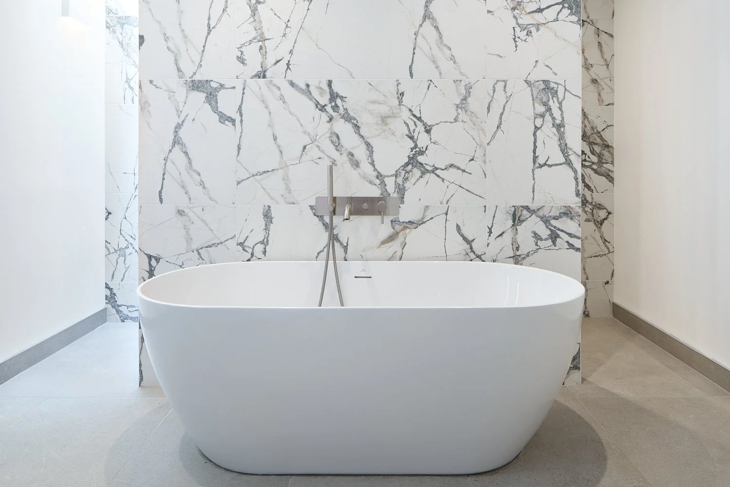 Main bathroom of newbuild home, white bath with grey and white marble wall - build home by FourSeven Homes, photographed by David Cordner.