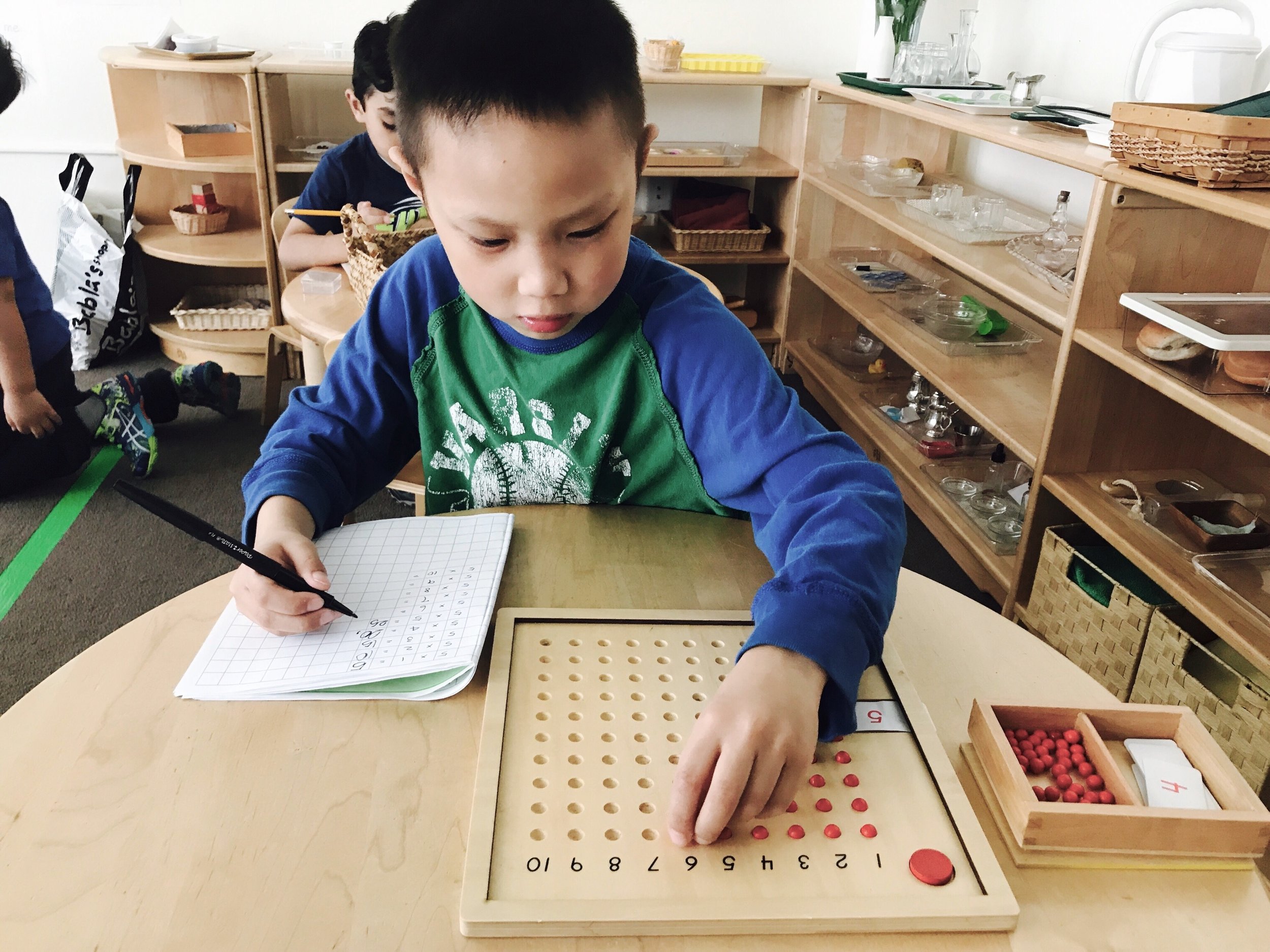 A child uses the Multiplication Board to independently solve a series of multiplication problems.