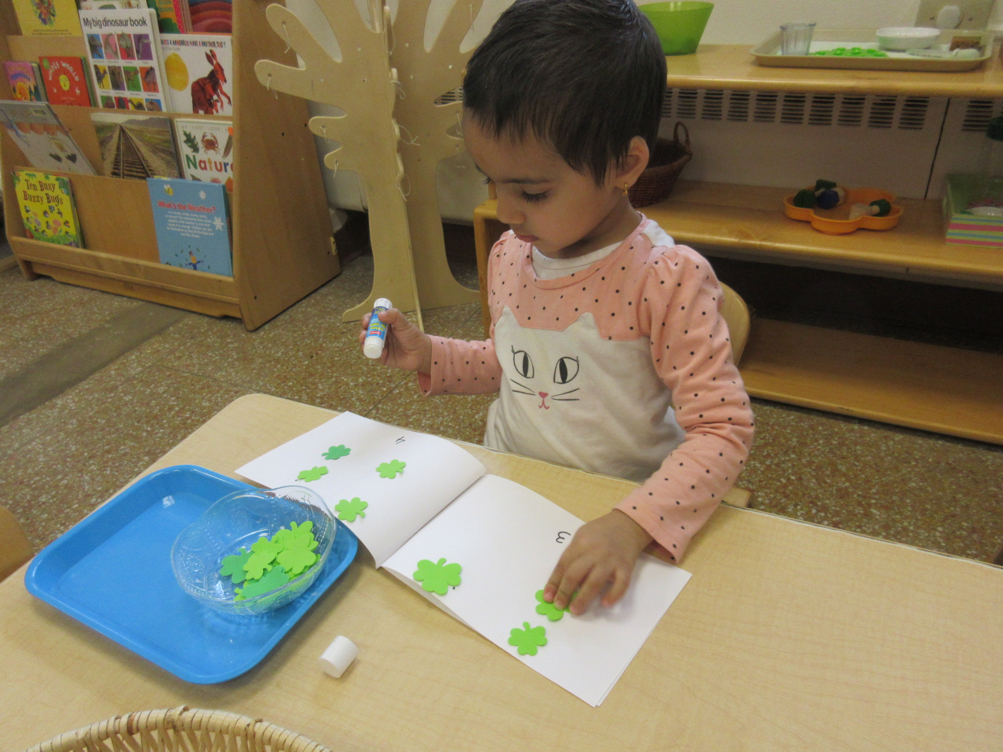 Pasting clovers onto our 1 through 5 counting books