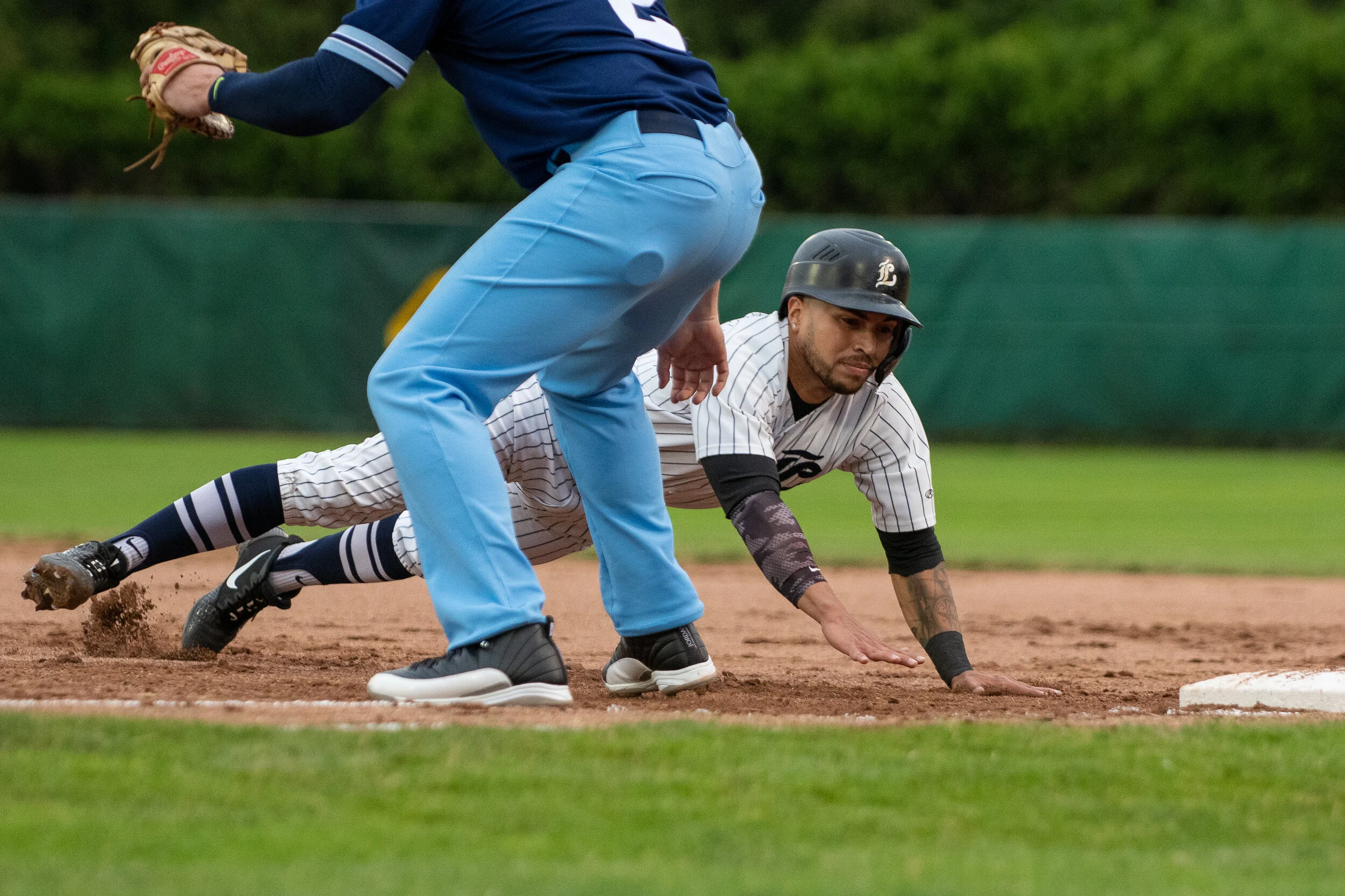  Carlos Arteaga dives back to first base on a cool night at Labatt Park July 9 — the first IBL game at the historic ballpark in nearly 700 days.  (Photo: Matt Hiscox Photography).  