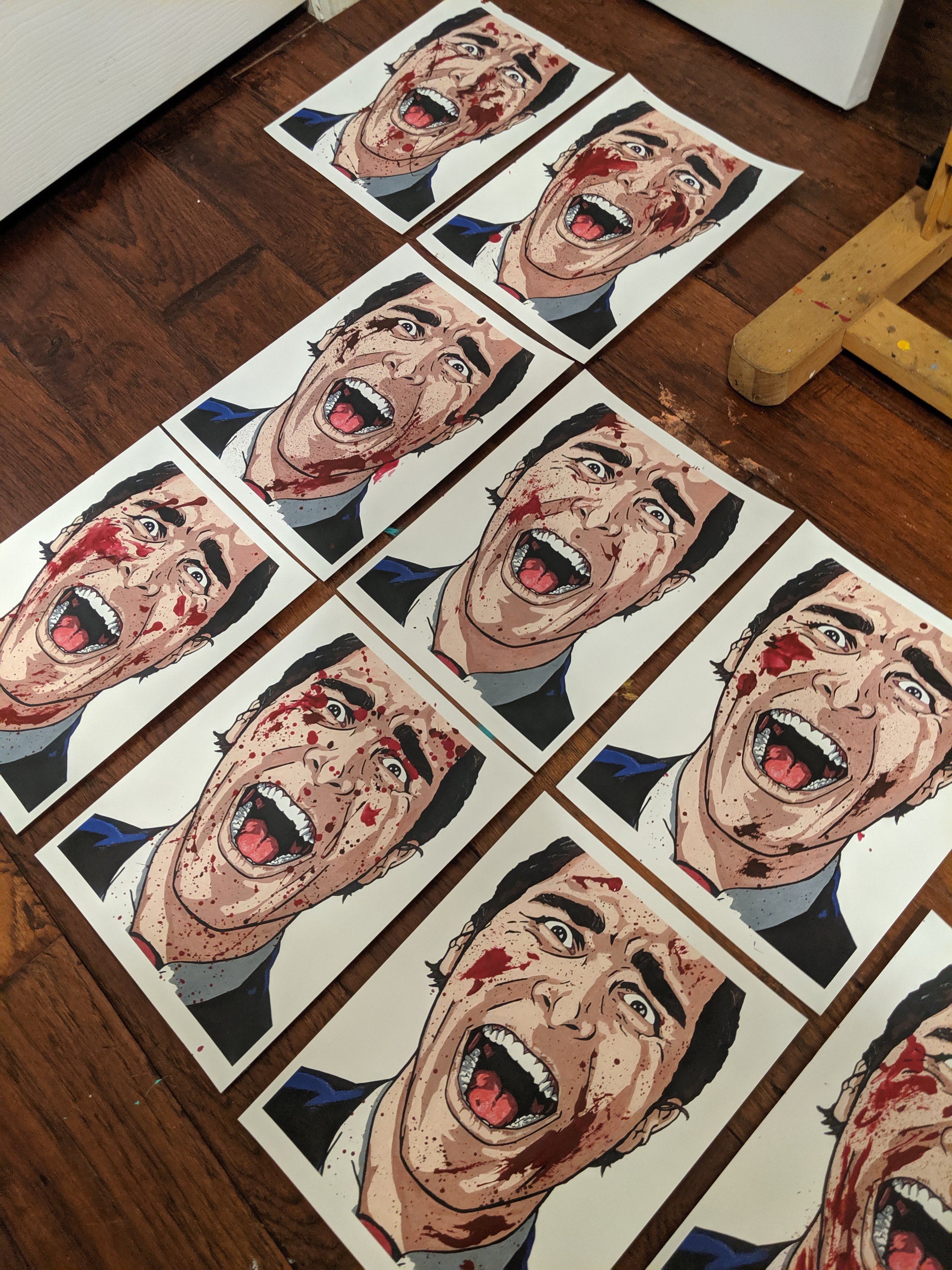 Hand finishing a series of Patrick Bateman prints with splatter