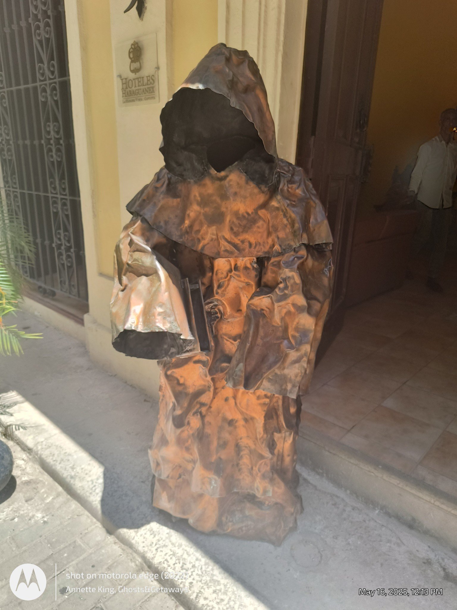 A person is dressed in a costume that appears to be made of fabric with a burnt or marbled pattern, covering their entire body and face