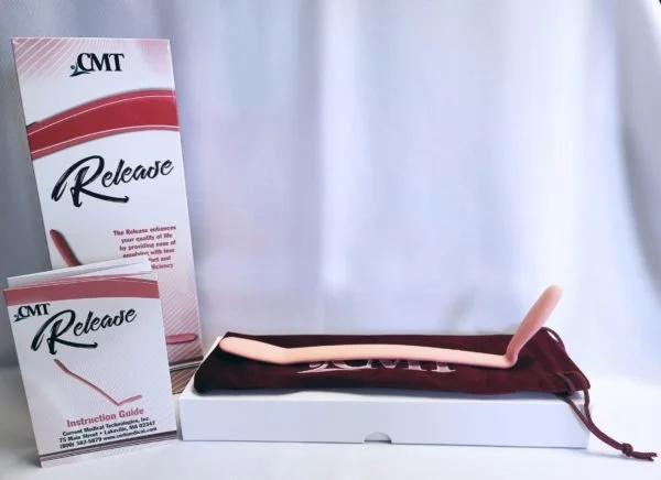 A white boxed item with a pink and white bent stick, a maroon cloth, a brochure, and a guide, displayed on a table with a white curtain background.