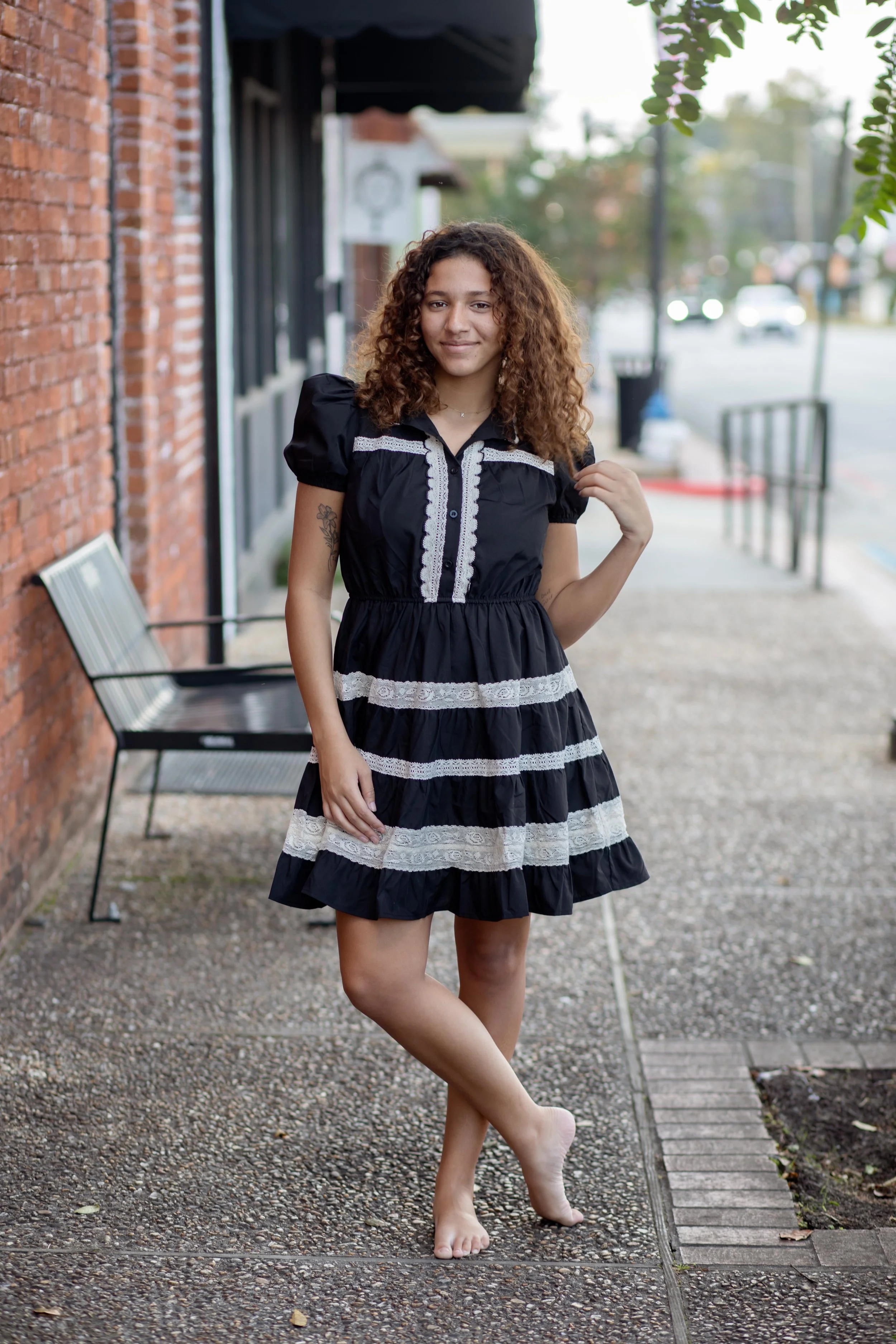 A mini dress featuring puff sleeves, a high neckline with scalloped lace trim, and a button-down front placket