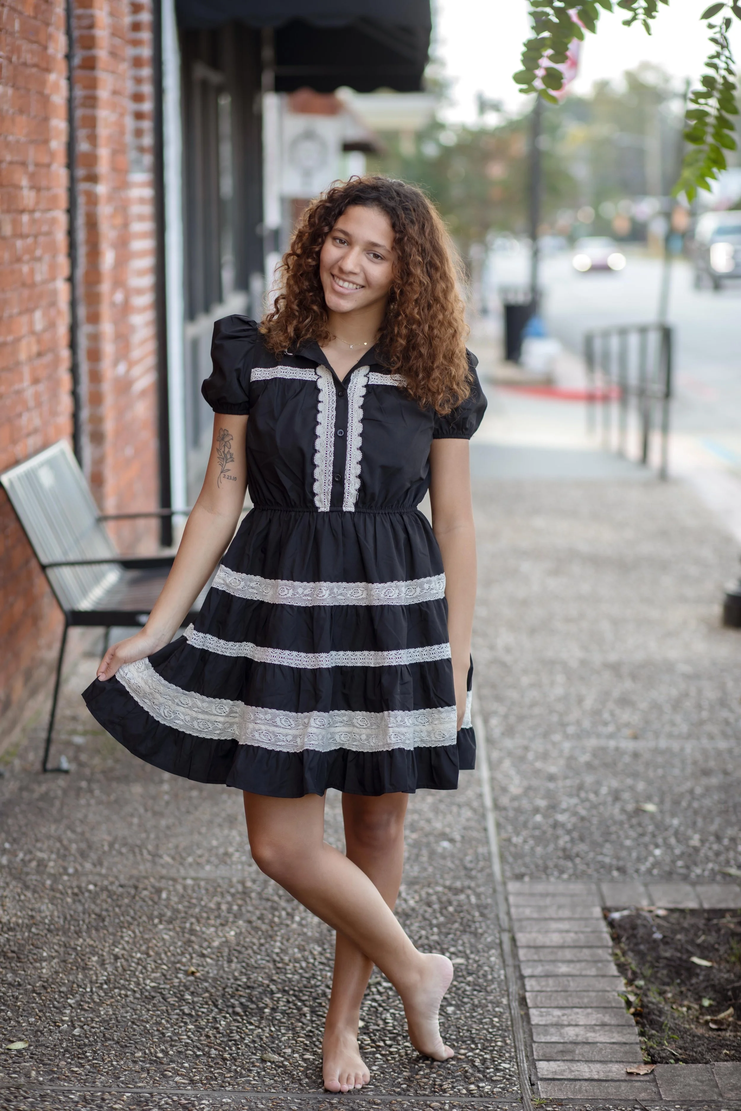 A mini dress featuring puff sleeves, a high neckline with scalloped lace trim, and a button-down front placket