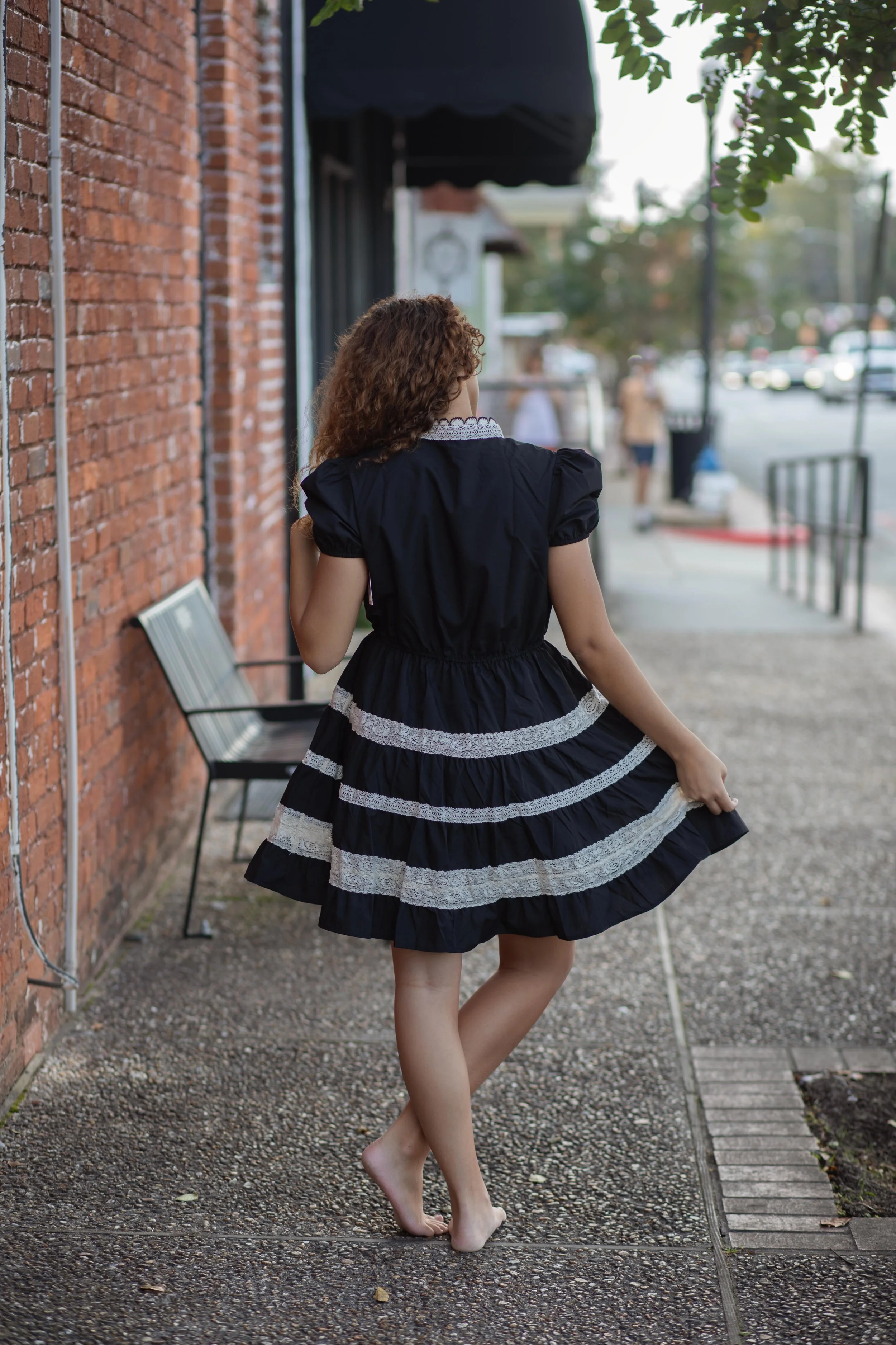 A mini dress featuring puff sleeves, a high neckline with scalloped lace trim, and a button-down front placket