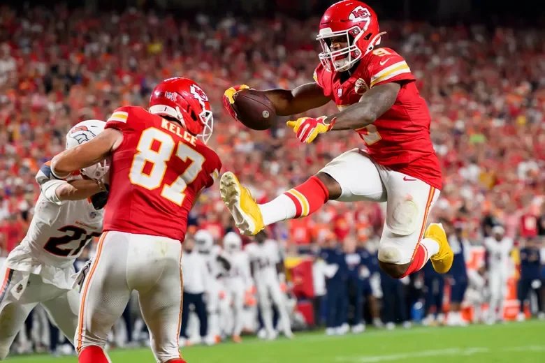 Kenneth walker III hurdling over player near Kelce Kansas City chiefs