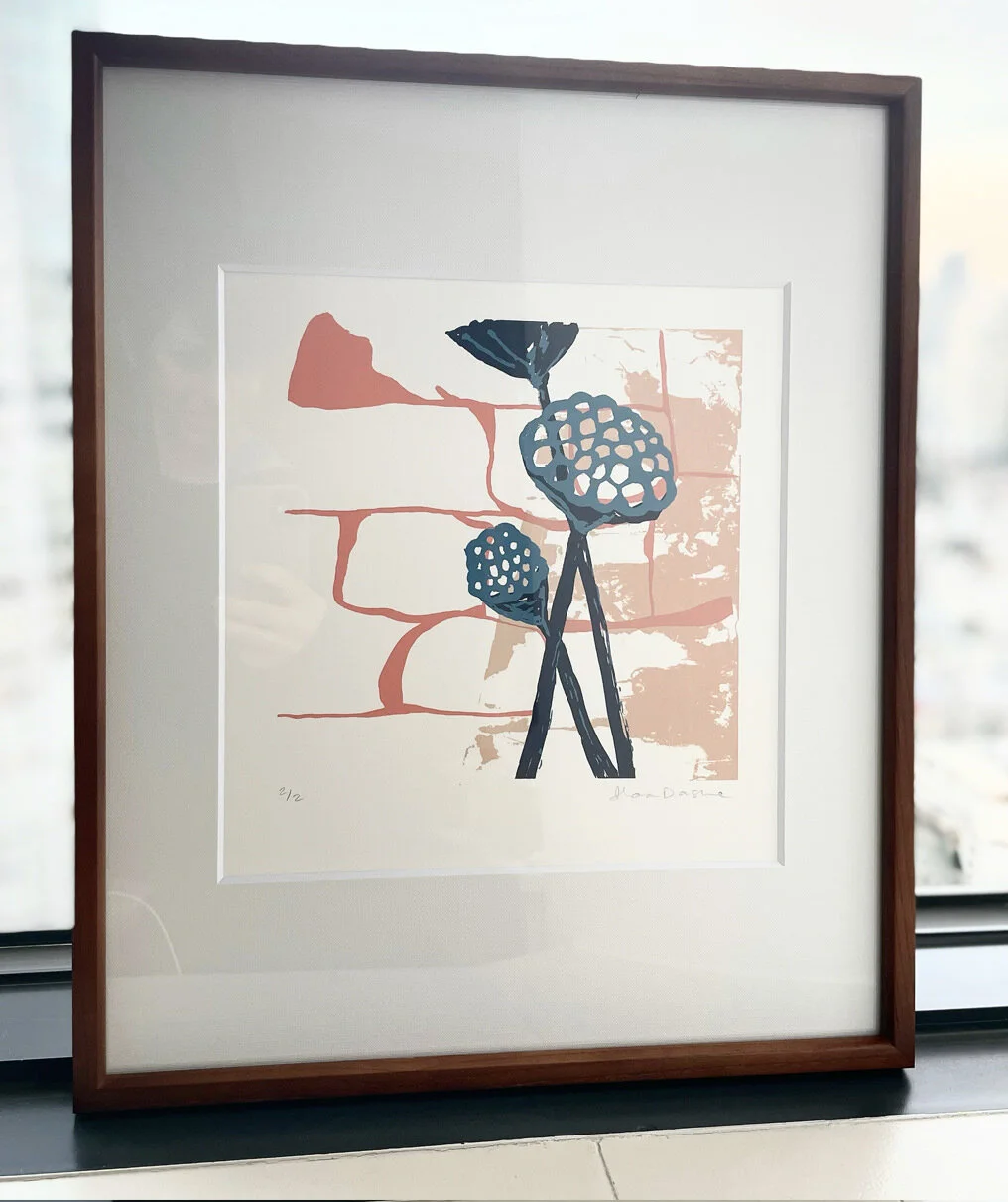 a lotus pods artwork sits in a frame