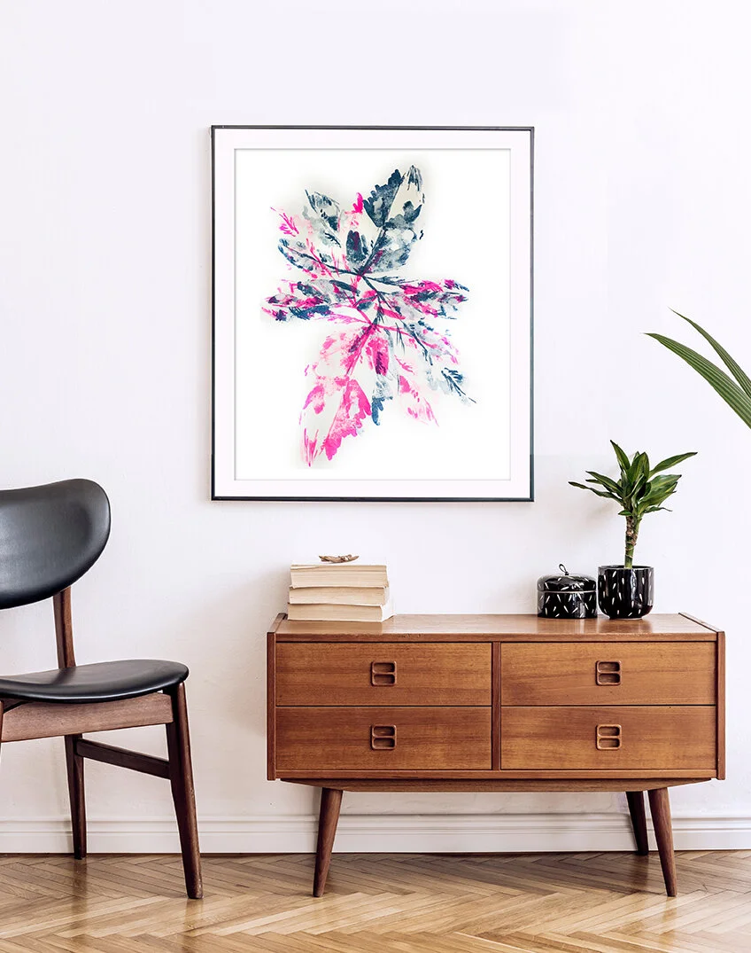 pink leaf art hangs in a frame