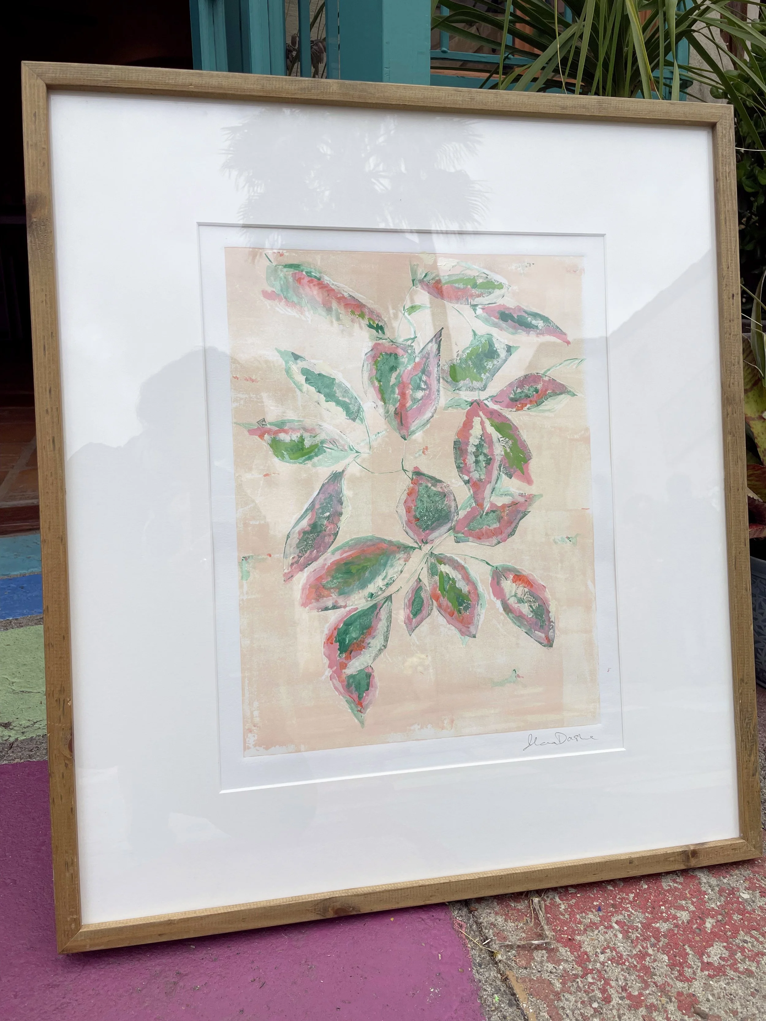 Framed artwork of pink ficus leaves with layered textures, set against a light background and displayed in a minimal wooden frame.