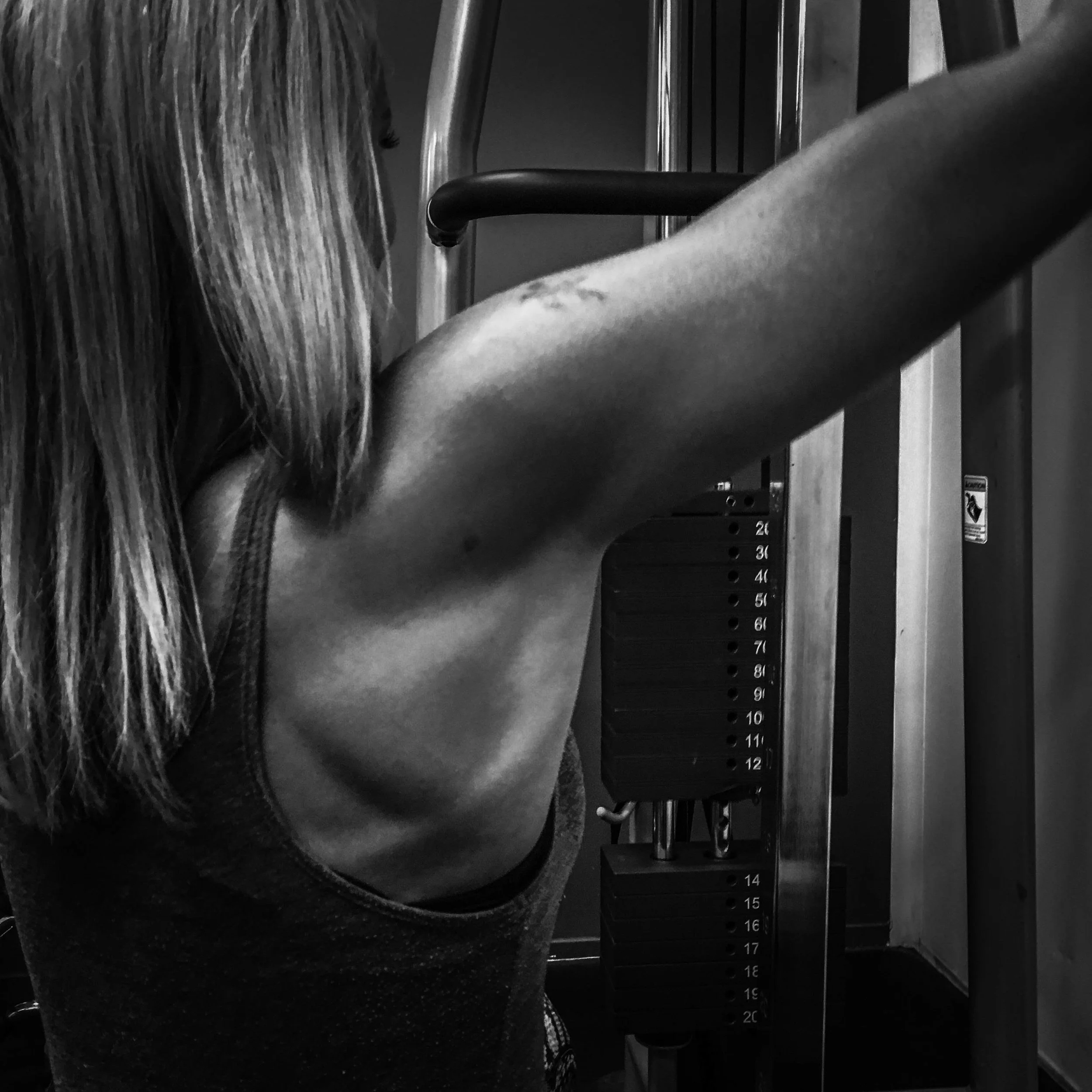 black and white, of muscle while personal training client is workoing out