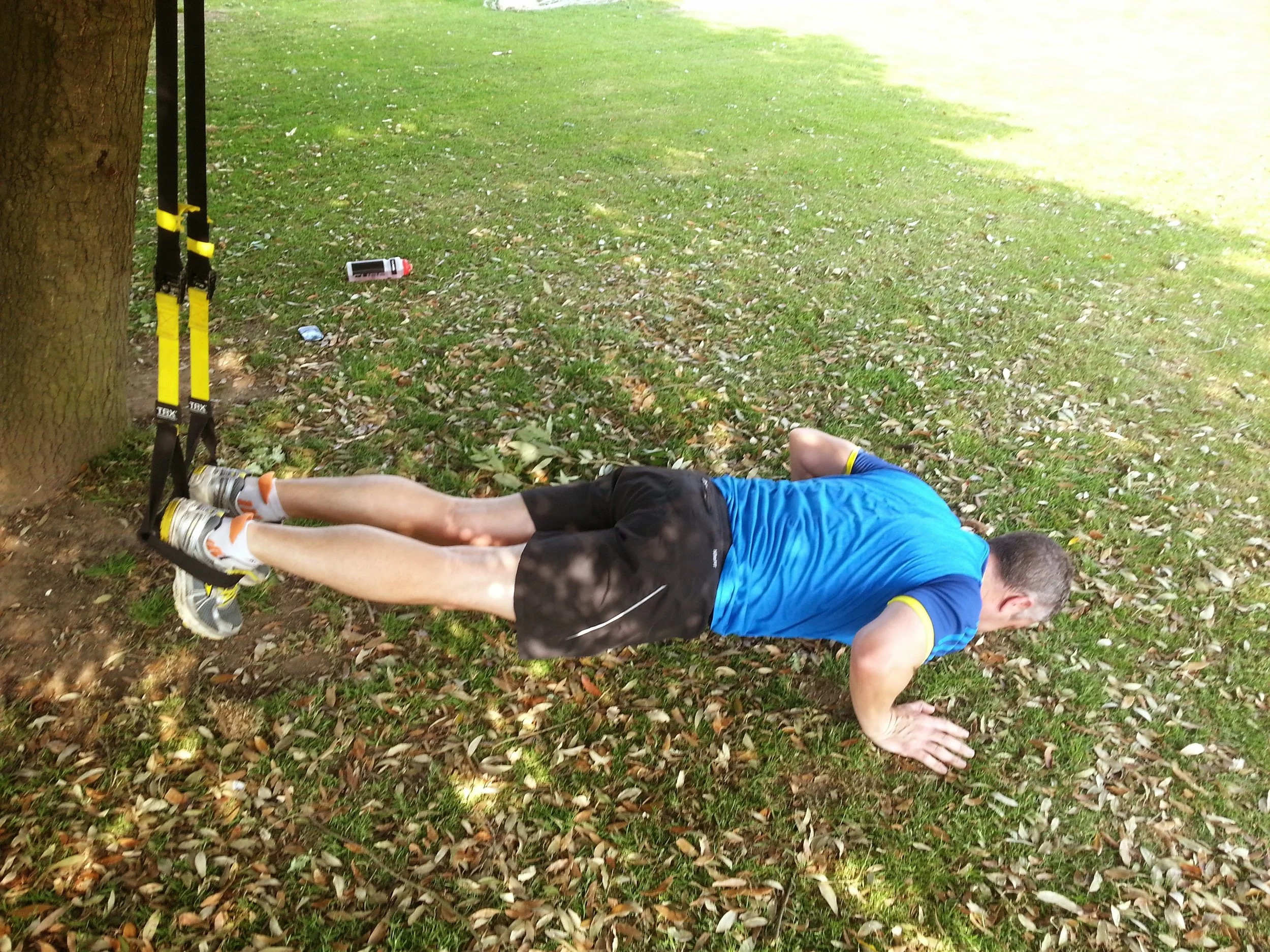 TRX training in the local park with mobile personal training client