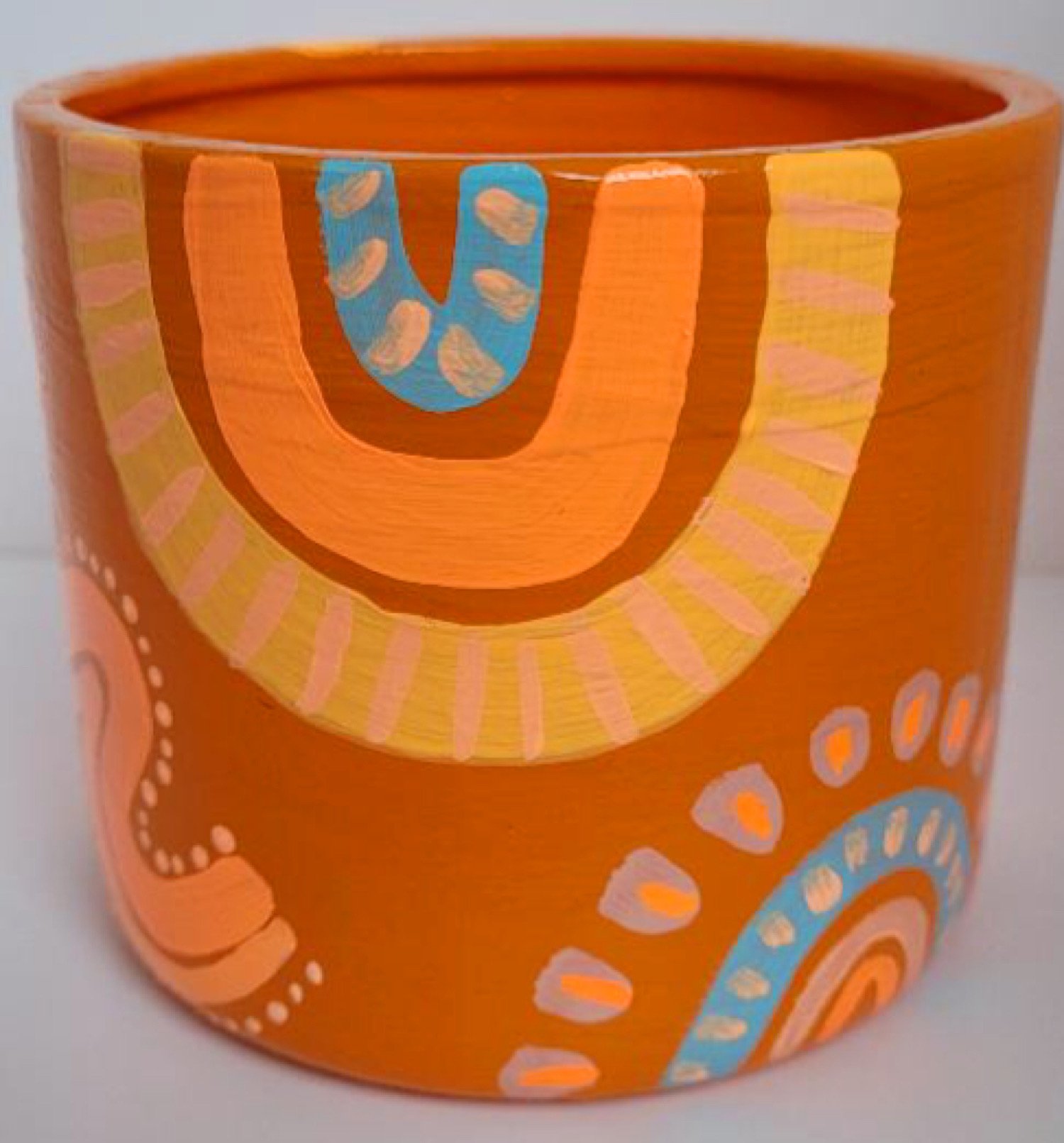 Fun exclusive handpainted ceramic plant pot orange with organic aboriginal abstract shapes, neon orange, peach, pinks, and cerulean blue