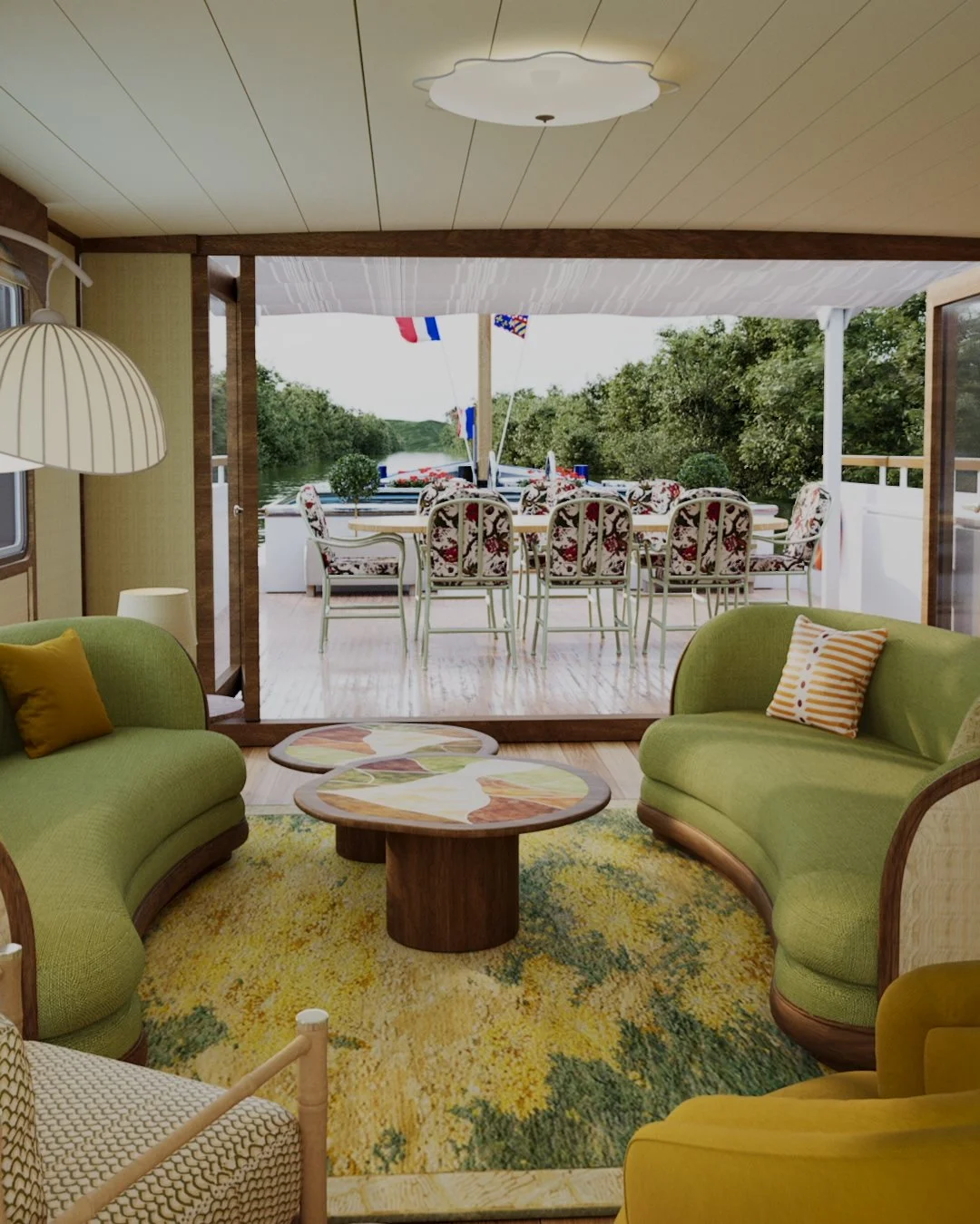 Living room with green curving sofas, colorful pillows, and a multicolored rug. Large windows open to a deck with a long dining table and chairs, overlooking a river and surrounded by trees.