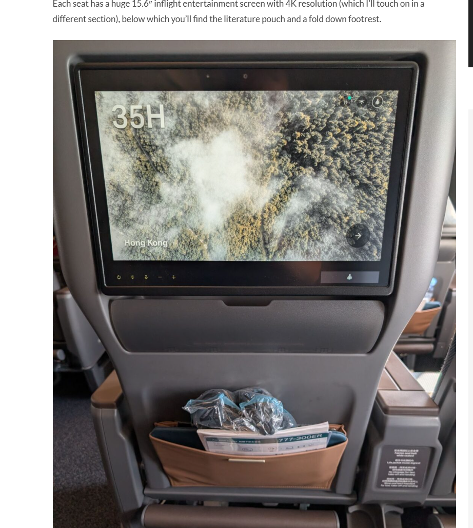 In-flight entertainment screen on an airplane showing a bird's-eye view map over Hong Kong, with the label "35H" and a background of trees and smoke.
