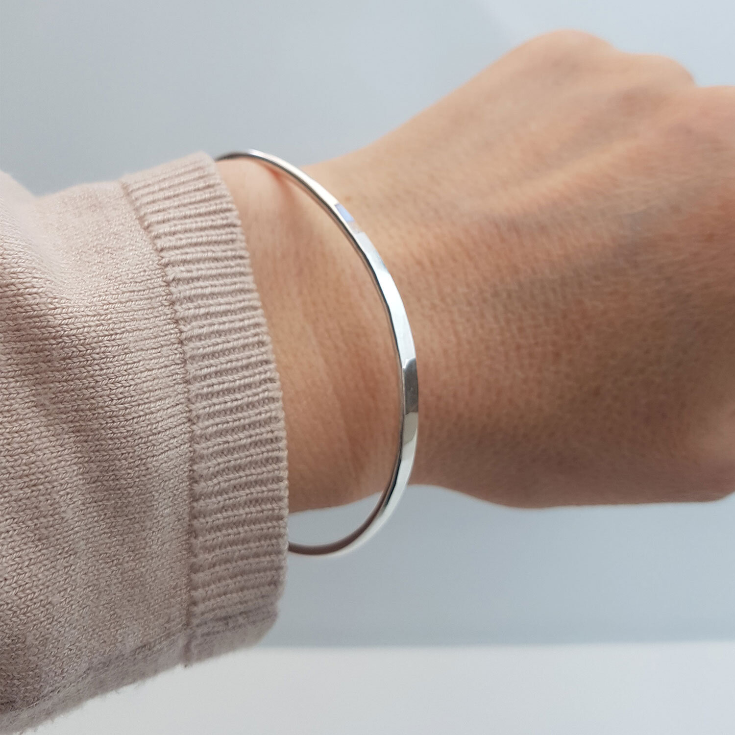 oval silver bangle on wrist