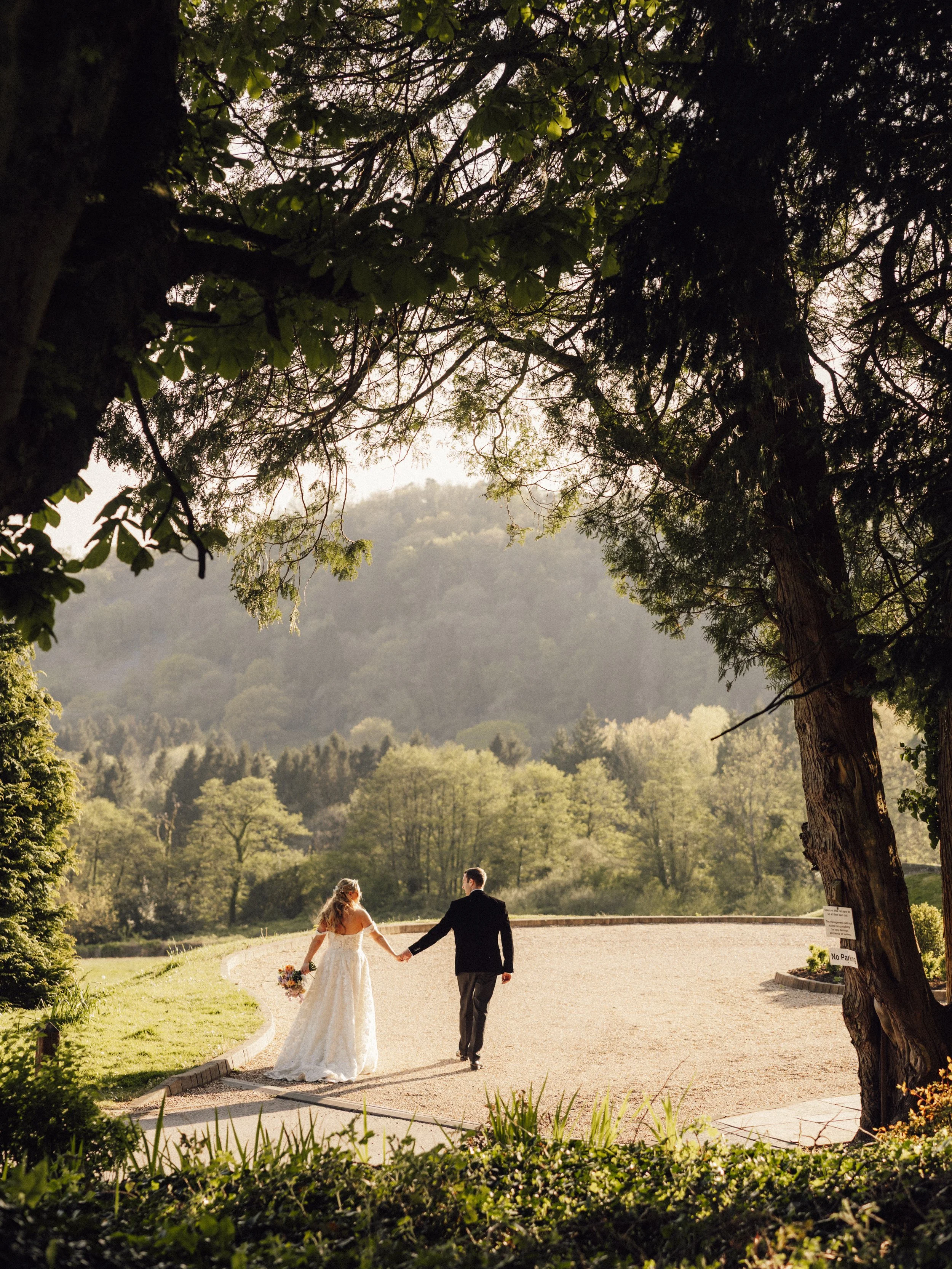 A groom leading his bride back to his guests, surrounded by stunning soft golden hour lighting.