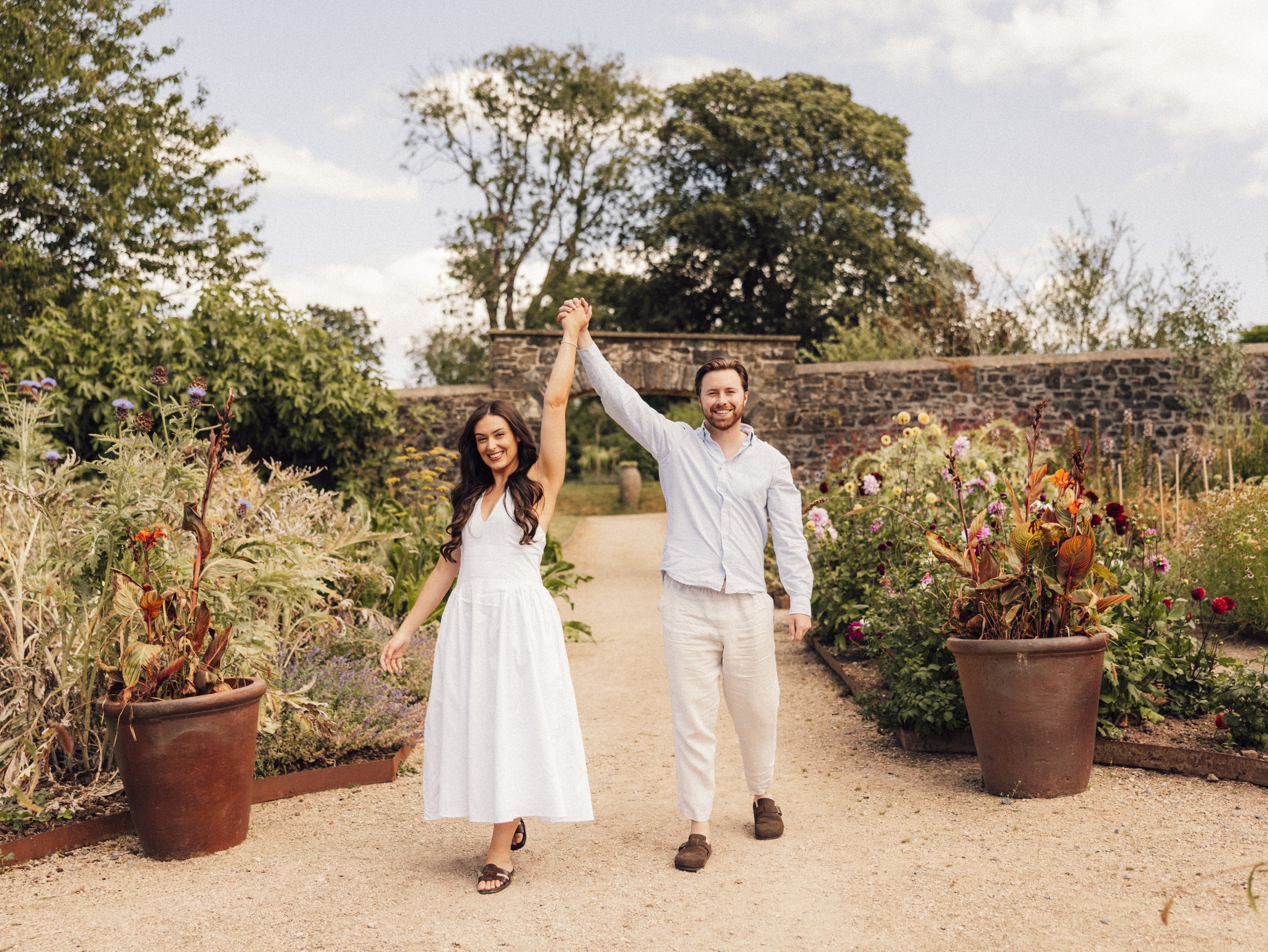 A fun image of a newly engaged couple holding hands in their Pembrokeshire wedding venue
