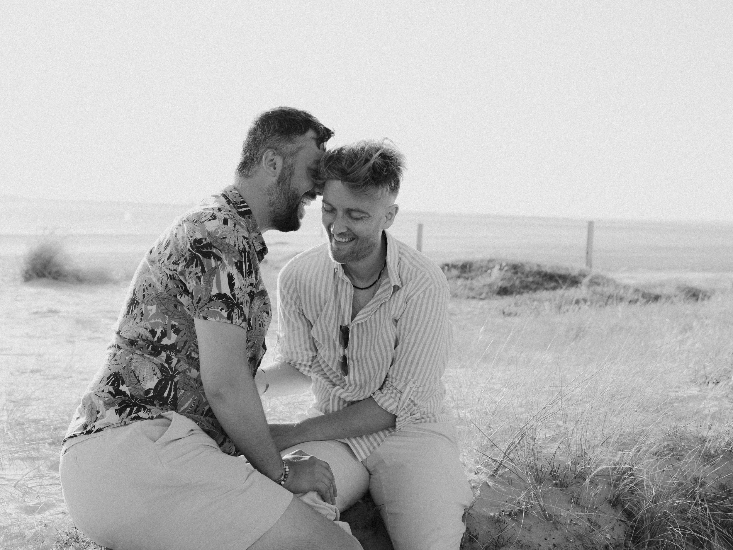 A black and white image of two men having an intimate moment ahead of their wedding day, with their LGBTQ+ photographer.