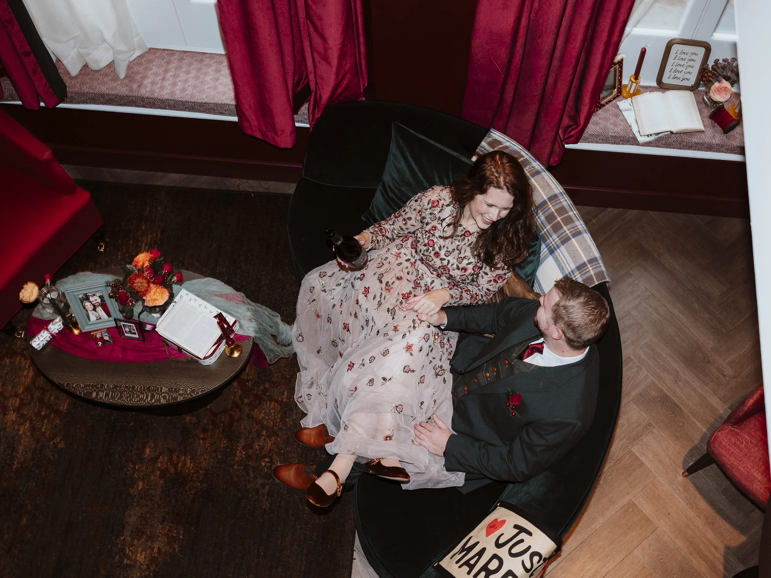 Bride and groom relaxing together on a velvet sofa at The Other House hotel in South Kensington, London before their intimate elopement.