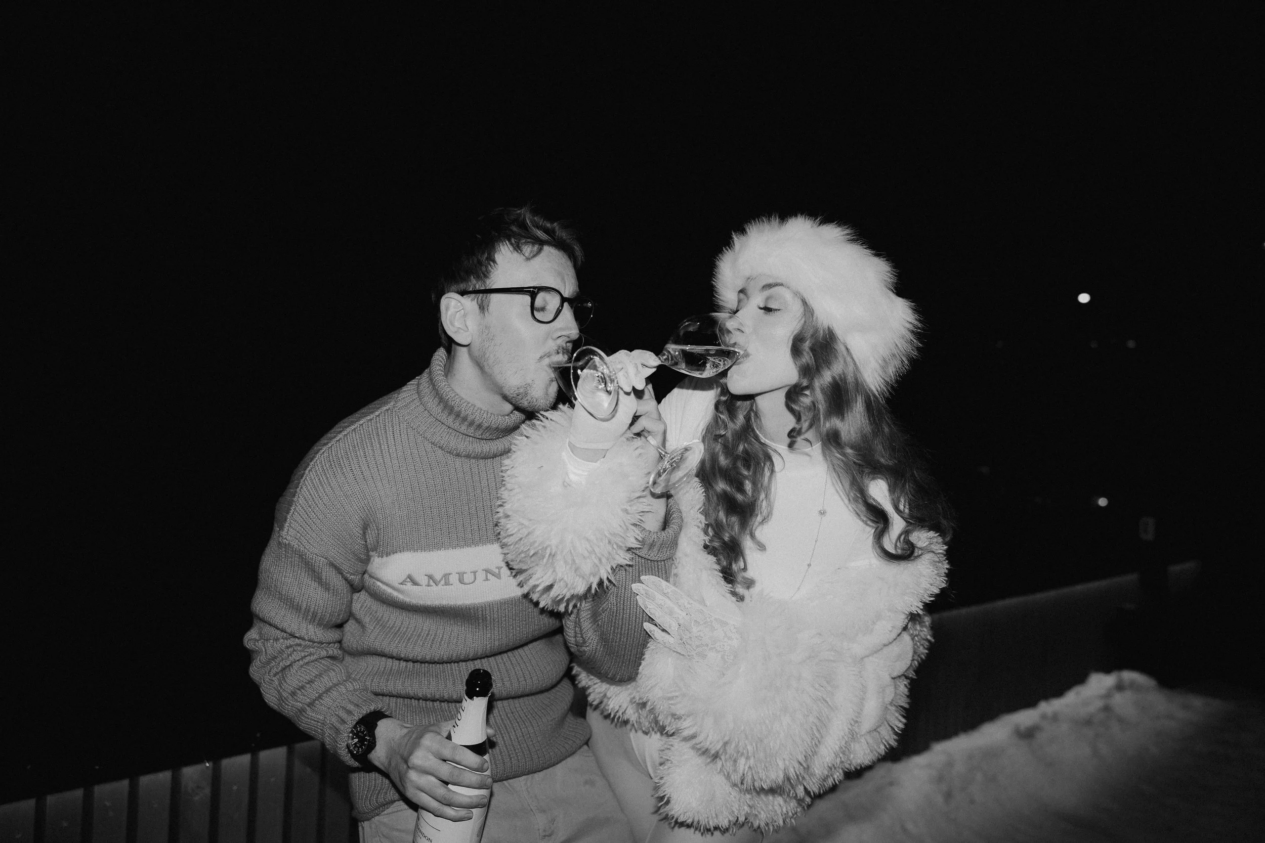 Couple celebrating with champagne during a winter destination elopement in Austria