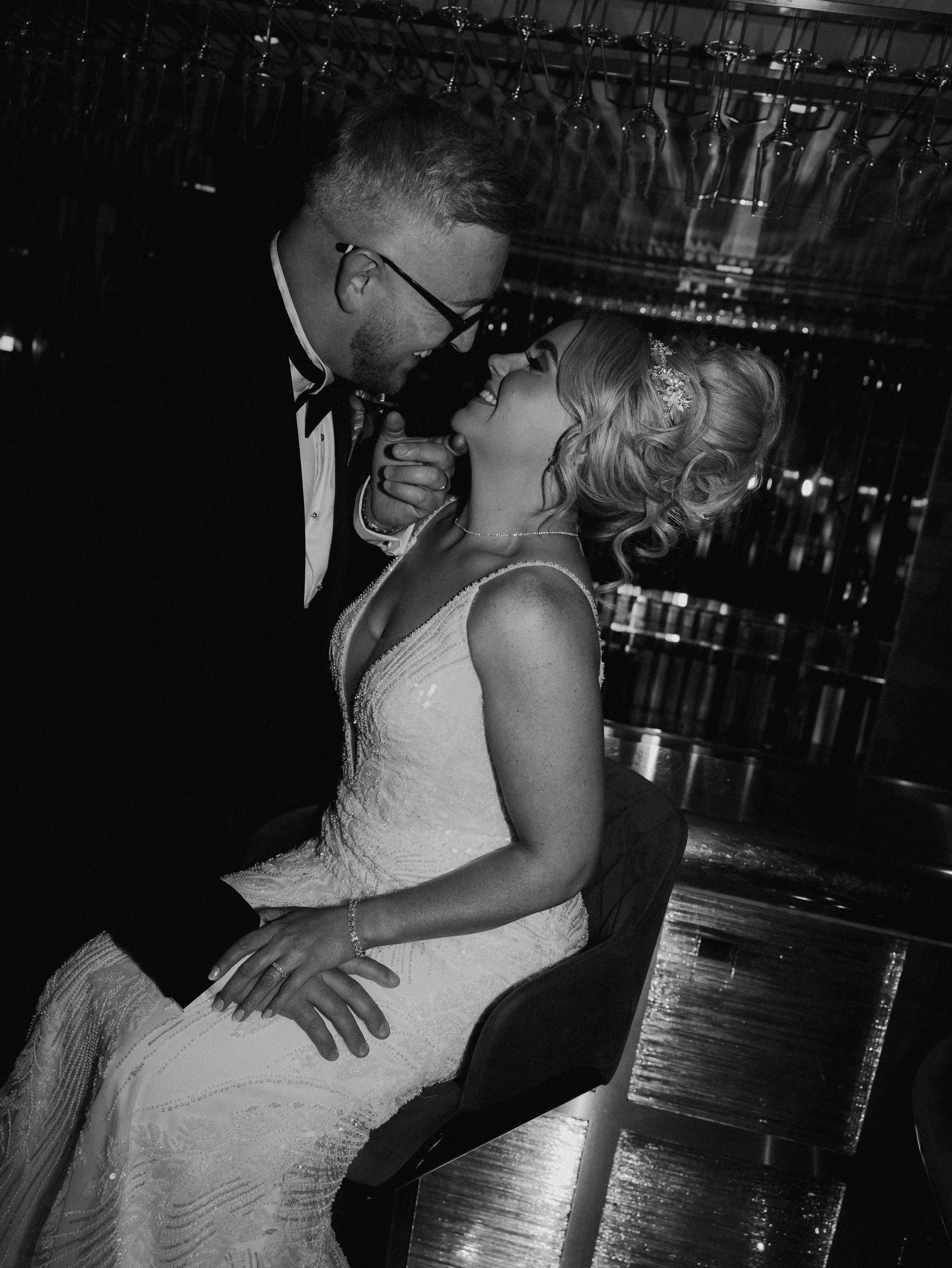 A black and white image of a newly married couple at the bar at Morgans hotel in Swansea.