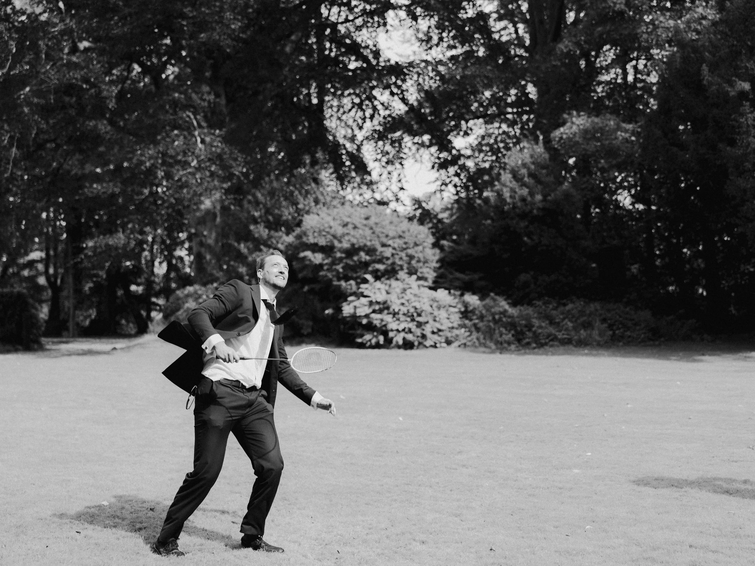 Candid moment of the groom enjoying garden games during a relaxed wedding day