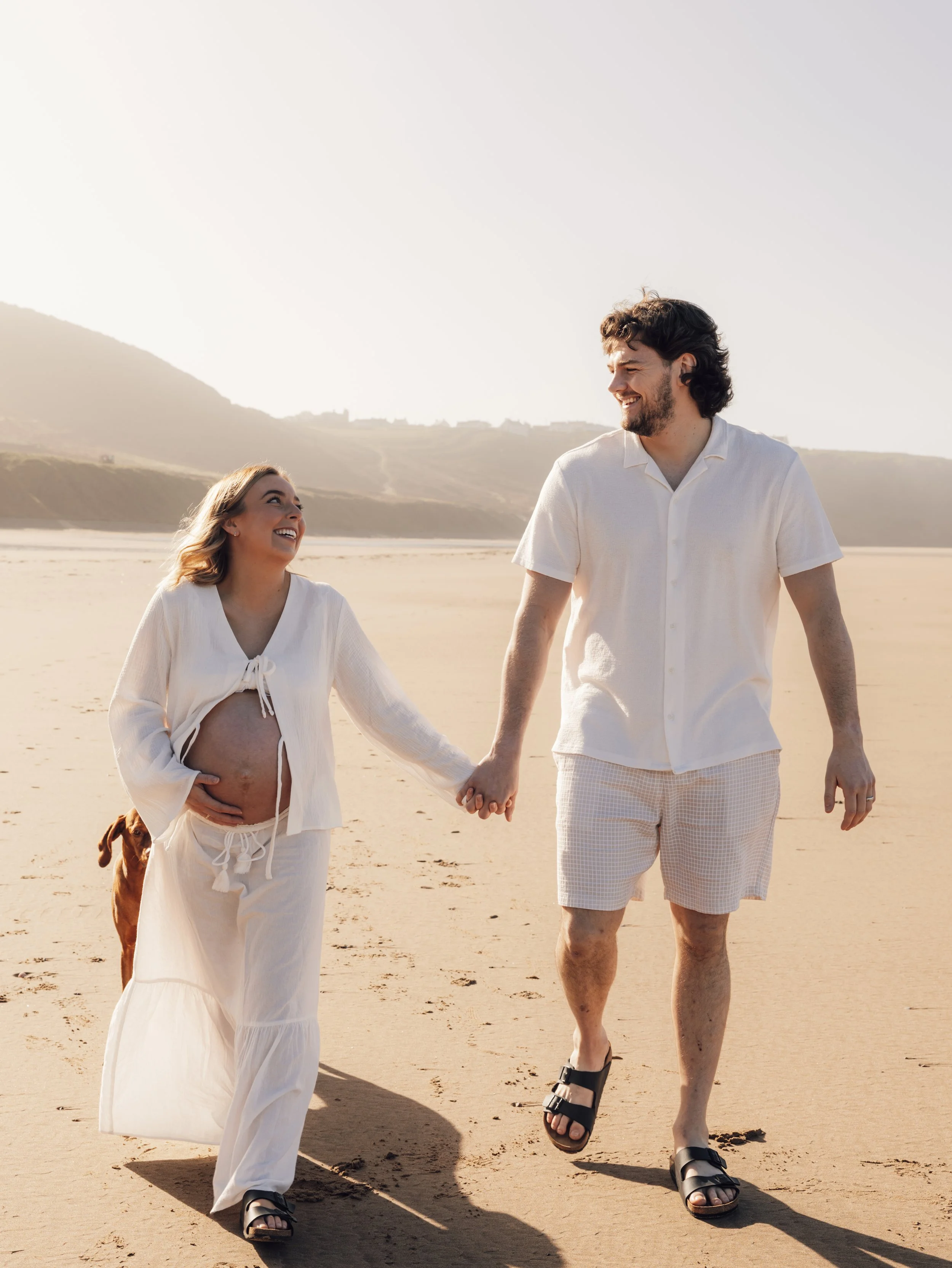 Coastal maternity shoot at sunset with calm ocean backdrop