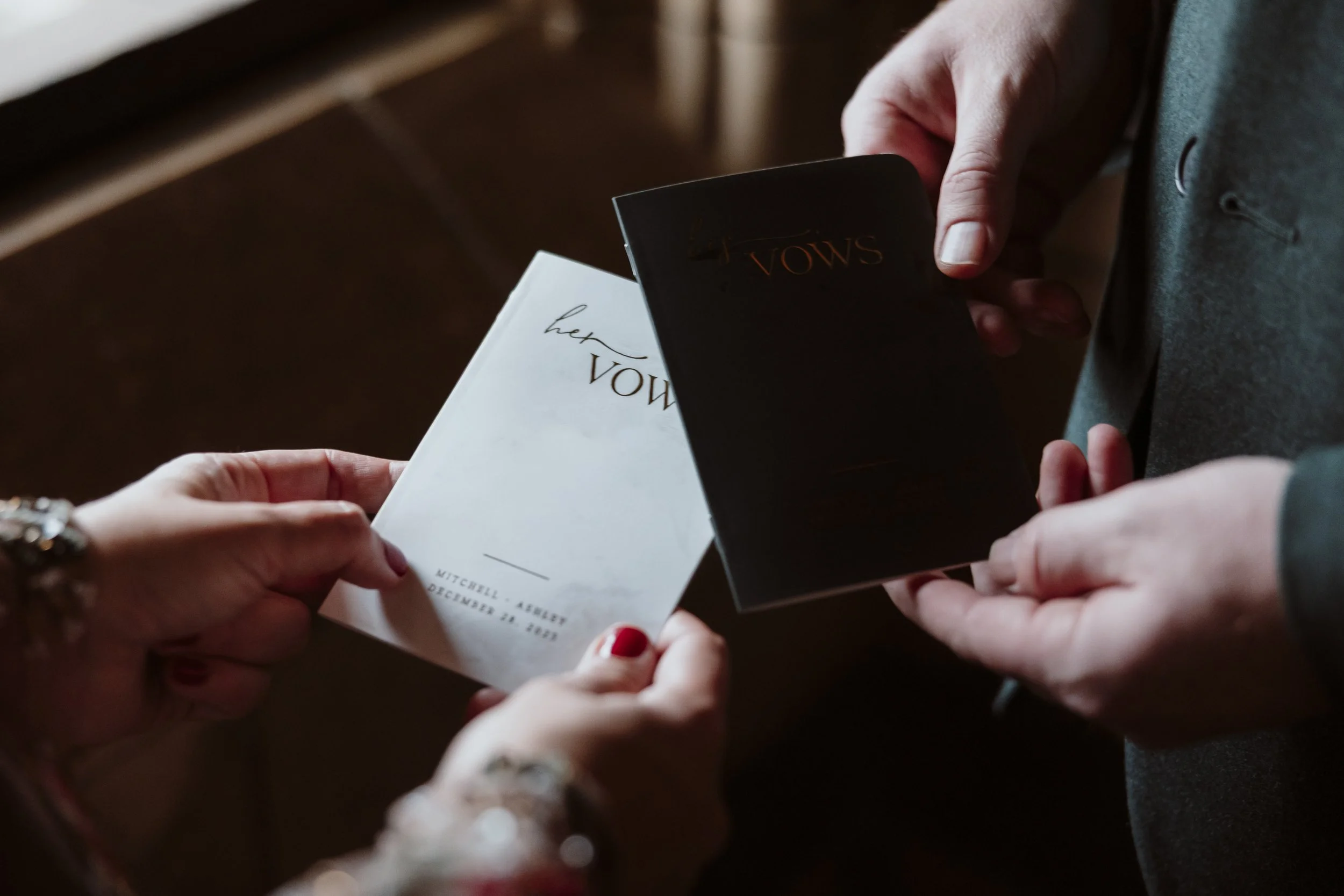 Close up of personalised wedding vow booklets held by a couple during their Natural History Museum elopement.