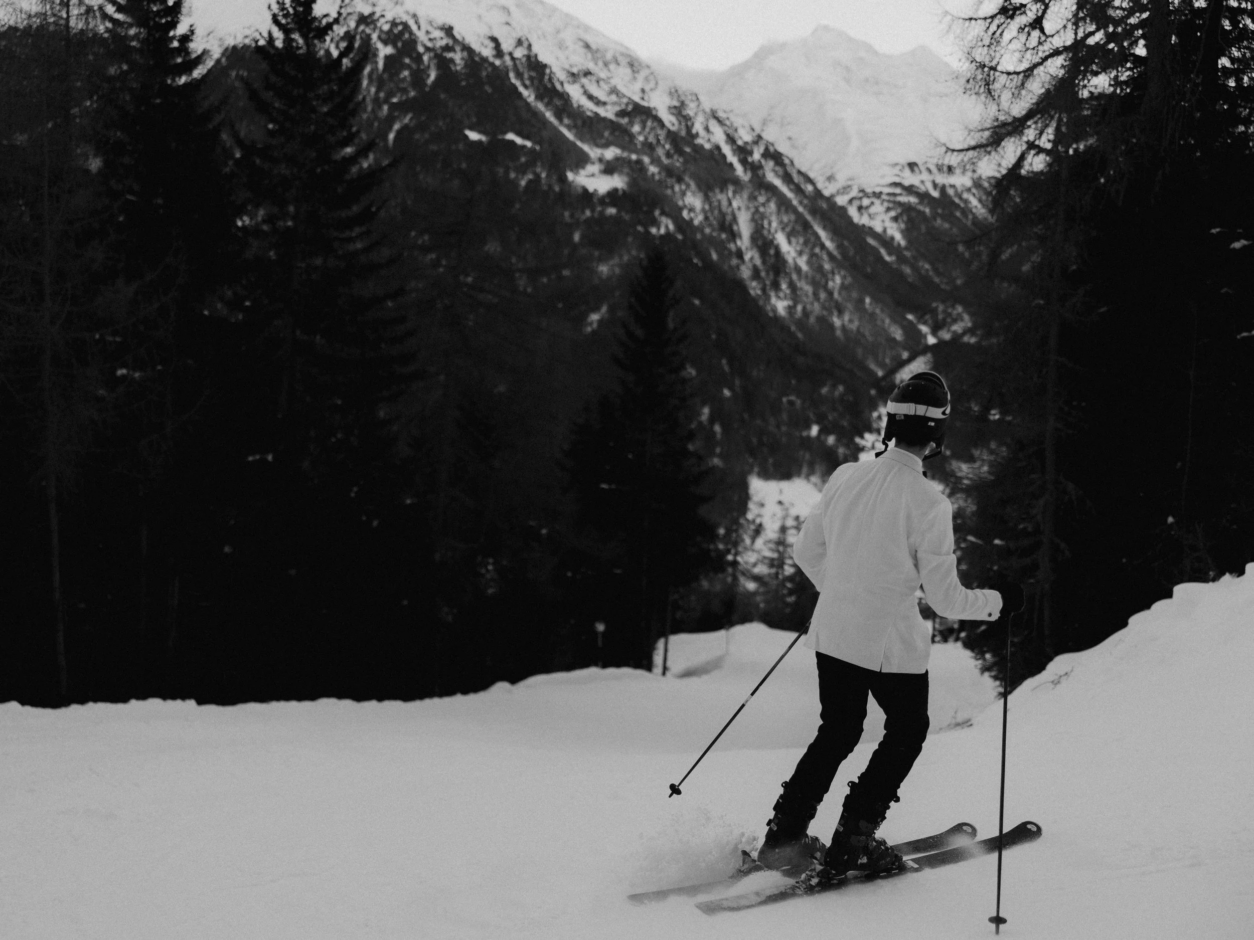 Groom skiing alone during a winter destination elopement in the Austrian Alps