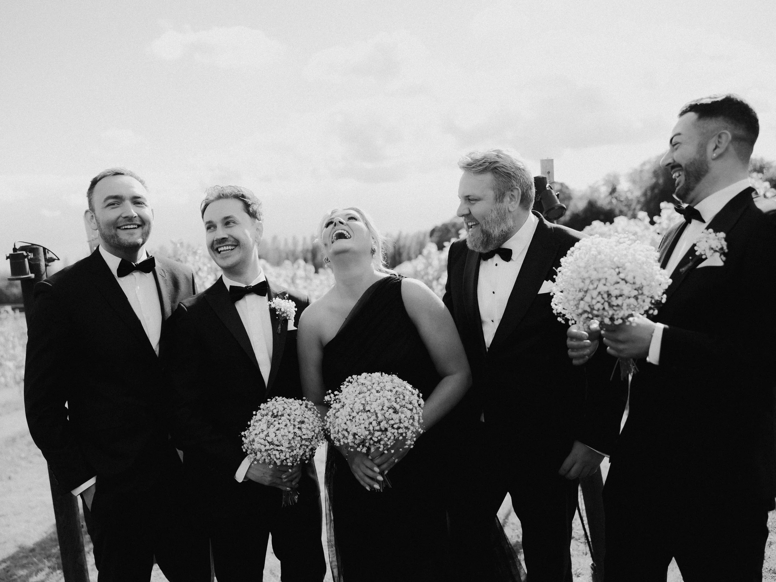 Wedding party laughing together during a relaxed summer wedding at Llanerch Vineyard in South Wales
