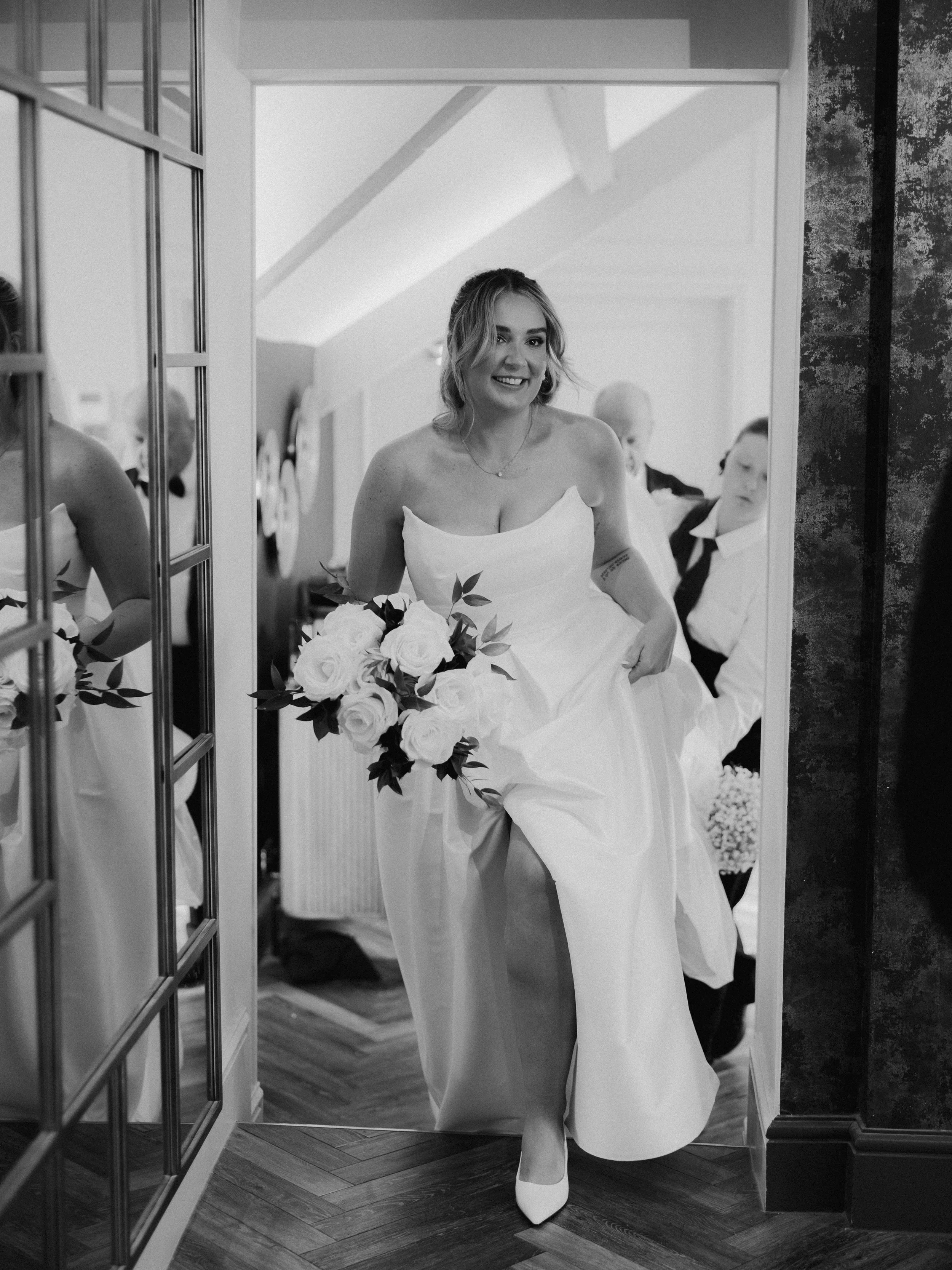 Bride walking through the doorway during morning preparations at a summer wedding at Llanerch Vineyard in South Wales