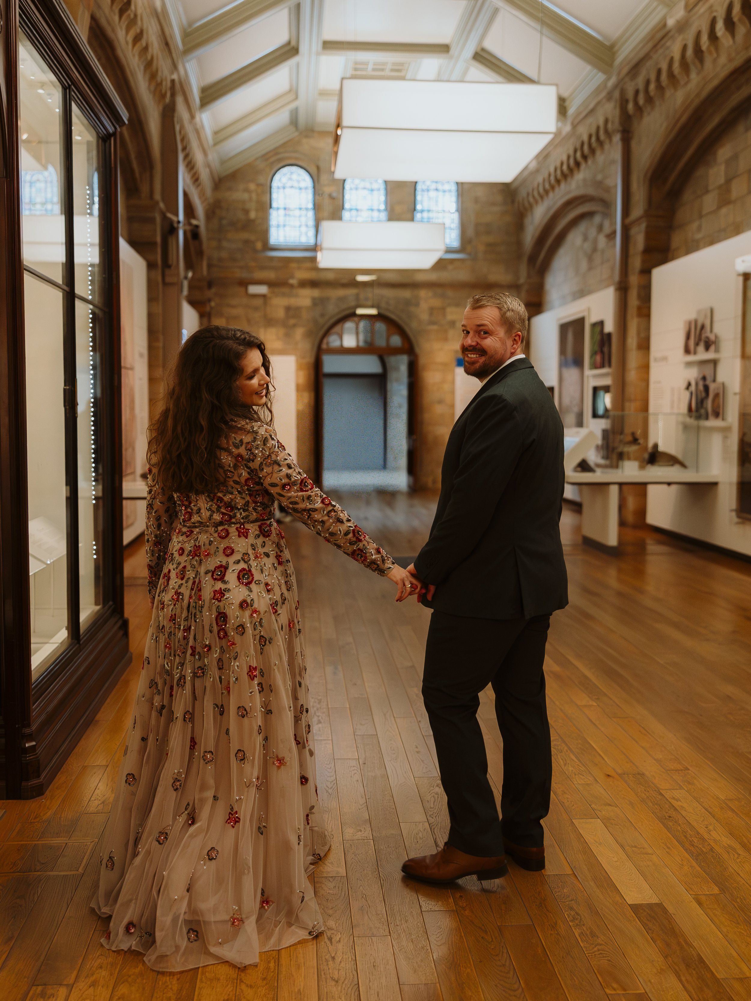 Newly married couple walking hand in hand through the Natural History Museum after exchanging private vows.