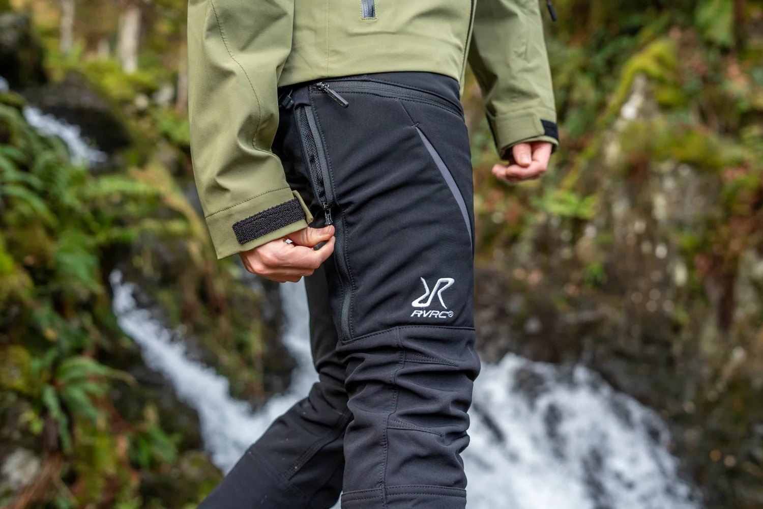Person wearing outdoor gear in nature, adjustable pants.
